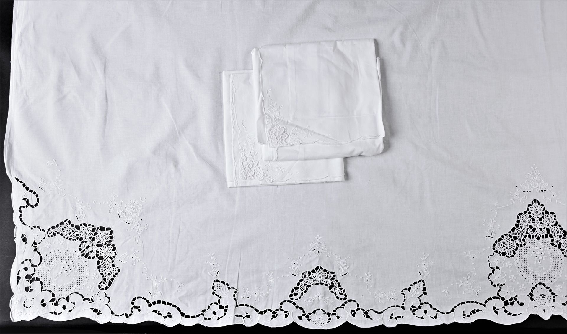 Null Richelieu刺绣床单套装，20世纪中期。
床单和它的一对枕套都是手工刺绣的，床单的反面有花卉装饰和小花束，边缘有扇形，枕套上绣有一朵角度的花。宽&hellip;