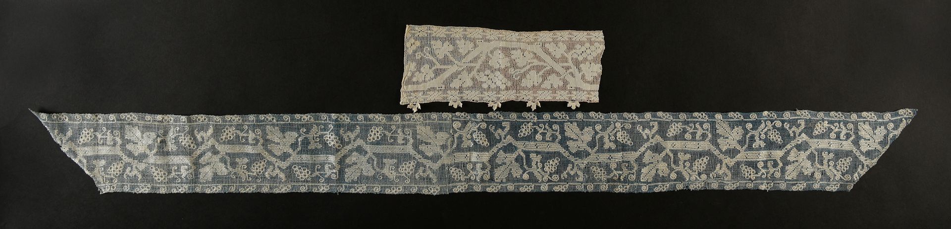 Null 两个边框，Buratto和葡萄拉线，意大利，17世纪初。

Buratto边框的纬线和经线都是靛蓝亚麻布，用奶油亚麻线刺绣，装饰有成串的葡萄、藤芽和藤&hellip;