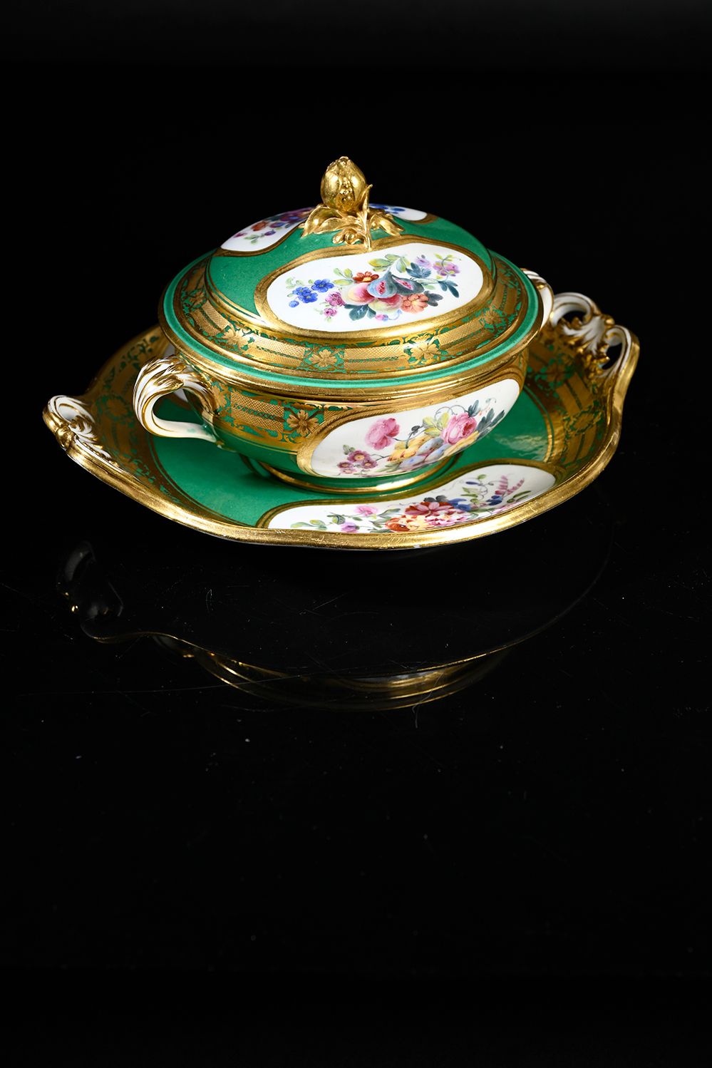 Sèvres 一个第一尺寸的瓷器 "nouvelle forme "碗和圆形托盘，有绿色背景和花卉装饰。
背面有交错的LL和代表1777年的字母日期Z，以及代表&hellip;