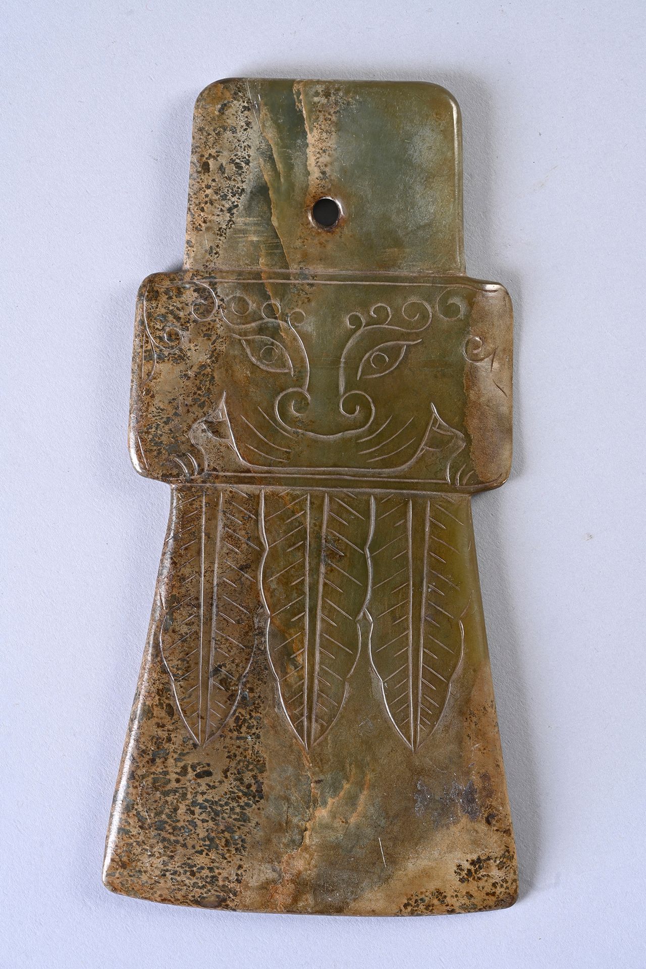 CHINE, Epoque Ming 斧刃
青玉，不透明，有铁锈纹，中间部分有浅浮雕的奇美拉面具的装饰。
长：21,7厘米。