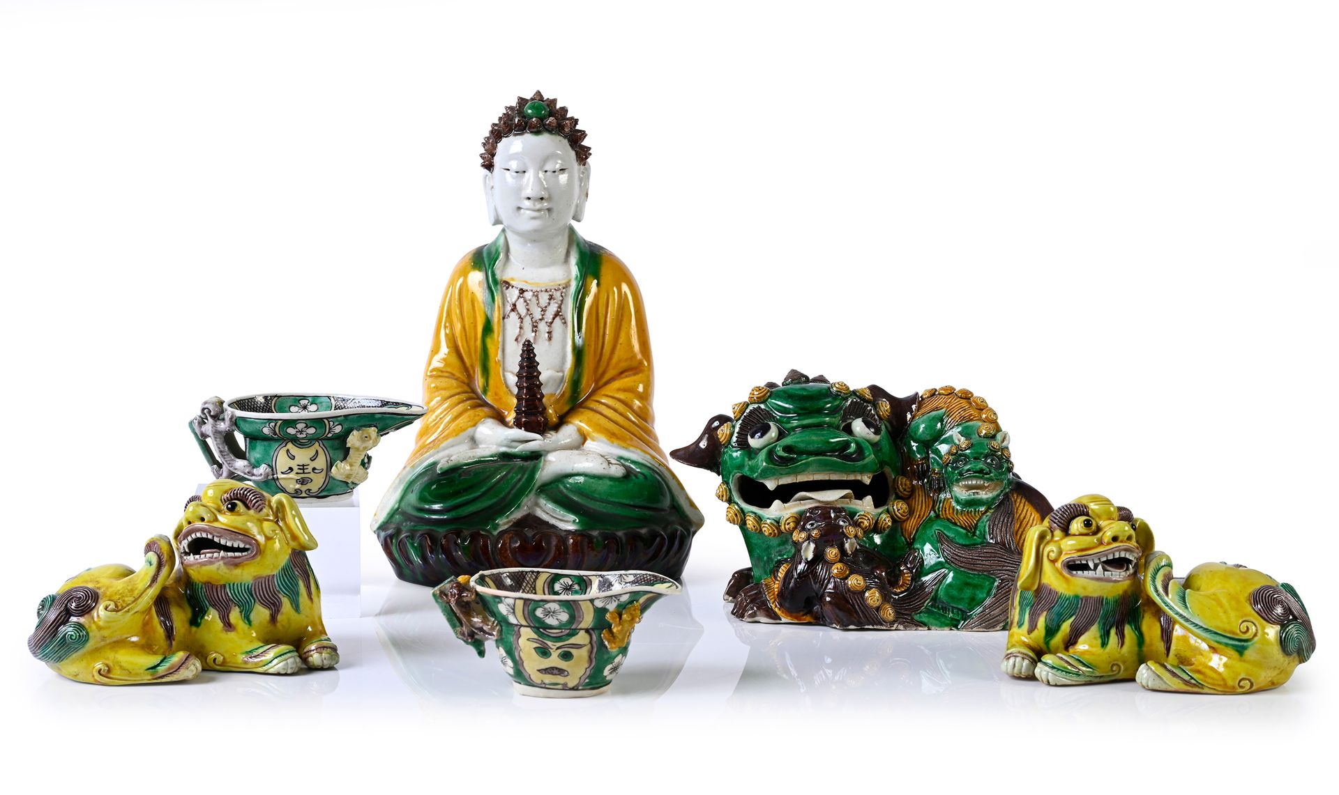 CHINE, Epoque Kangxi* 一套六件三色釉的陶瓷作品，被称为 "三彩"。
包括一尊坐佛，一对坐禅，一只佛狗，和两个酒杯。
高度：8.5至24.5&hellip;
