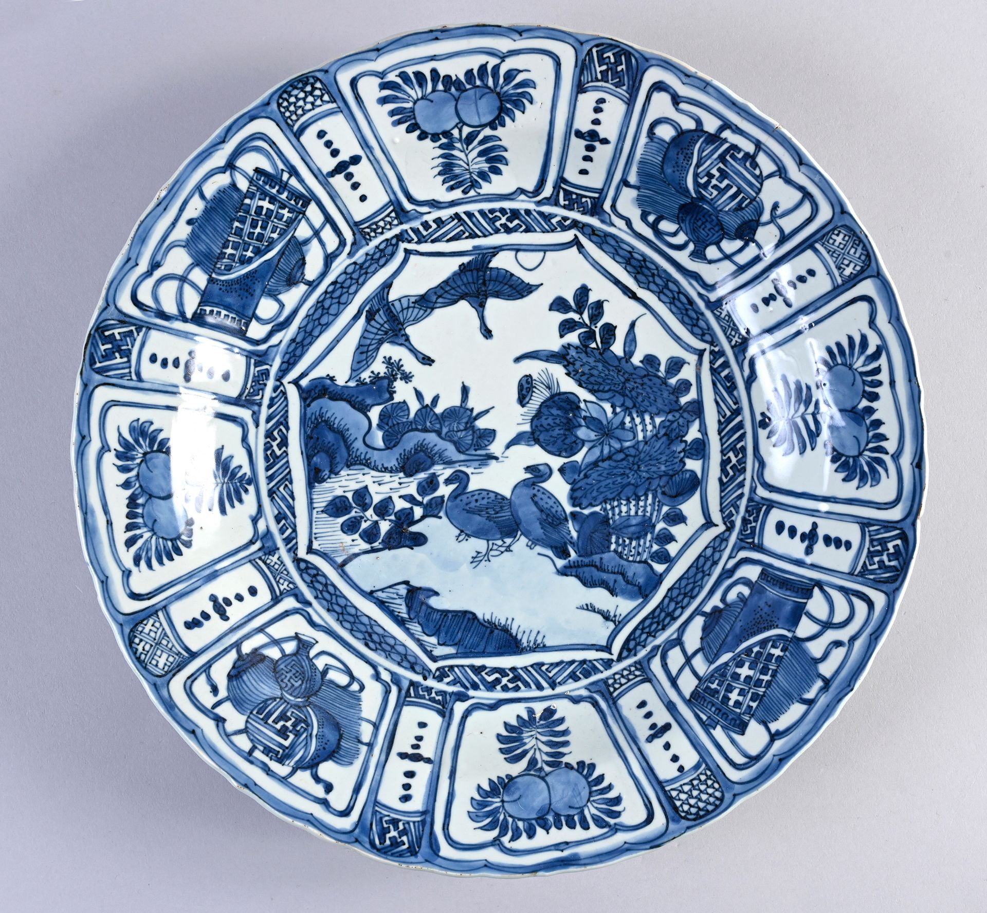 CHINE, Epoque Wanli, XVI-XVIIe siècle* 一个大的瓷盘，上面有Kraak的装饰，中央是鹅和鸭子在河边的场景，周身装饰着花瓣状&hellip;