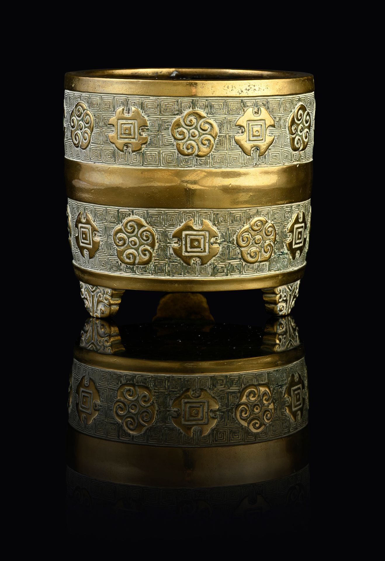 CHINE, XVIIe siècle 一个小型的铜制香水炉，圆柱形的炉身靠在三只脚上，装饰着希腊背景上的双楣花纹。底下刻有一个六字的宣德款。
高：6厘米
直径&hellip;
