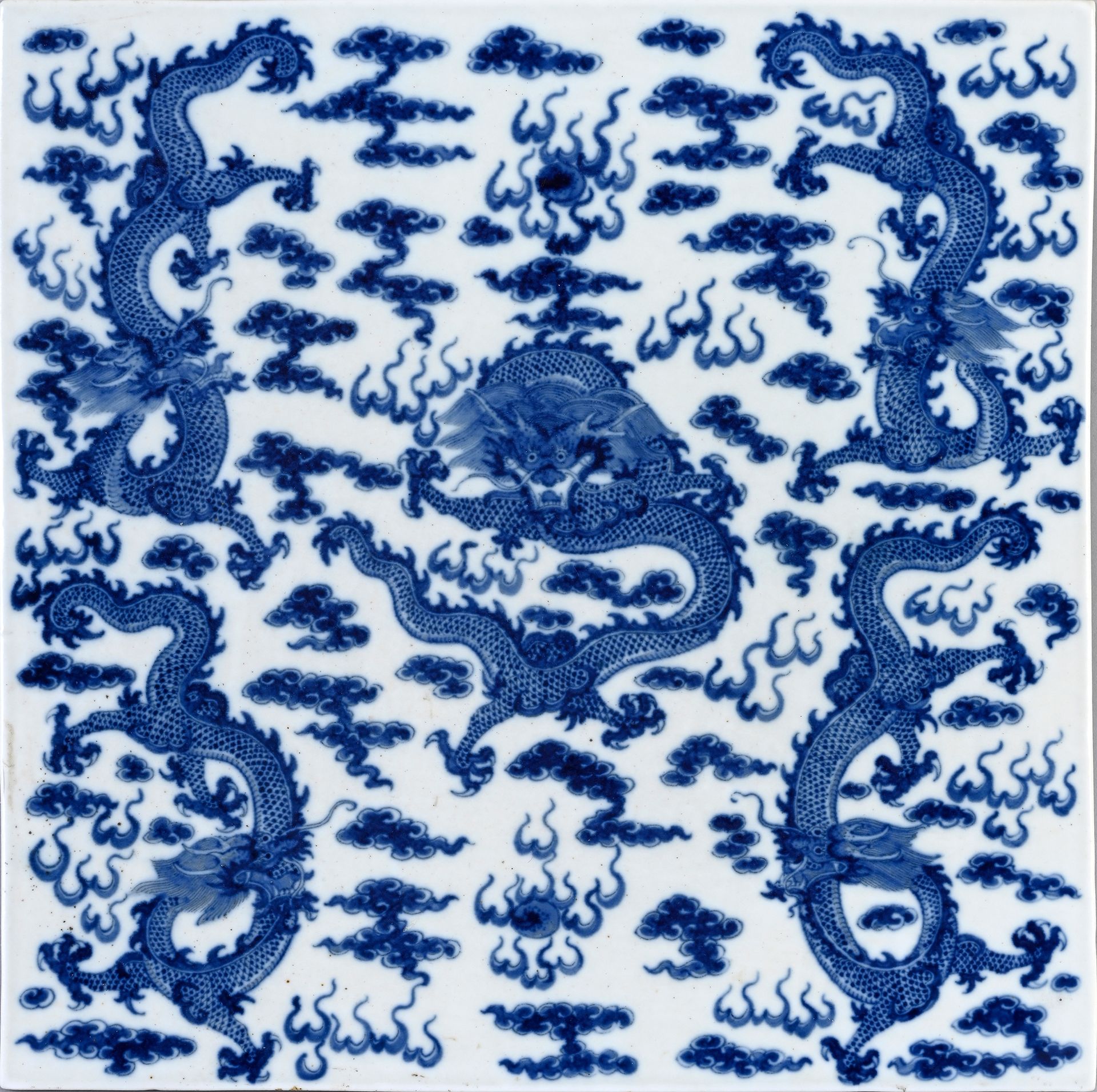 CHINE, XIXe siècle* 瓷板一对
方形，白底钴蓝装饰，五条四爪龙，身体蜿蜒，正面和侧面描绘了在云间追逐圣珠的情景。
32 x 32厘米