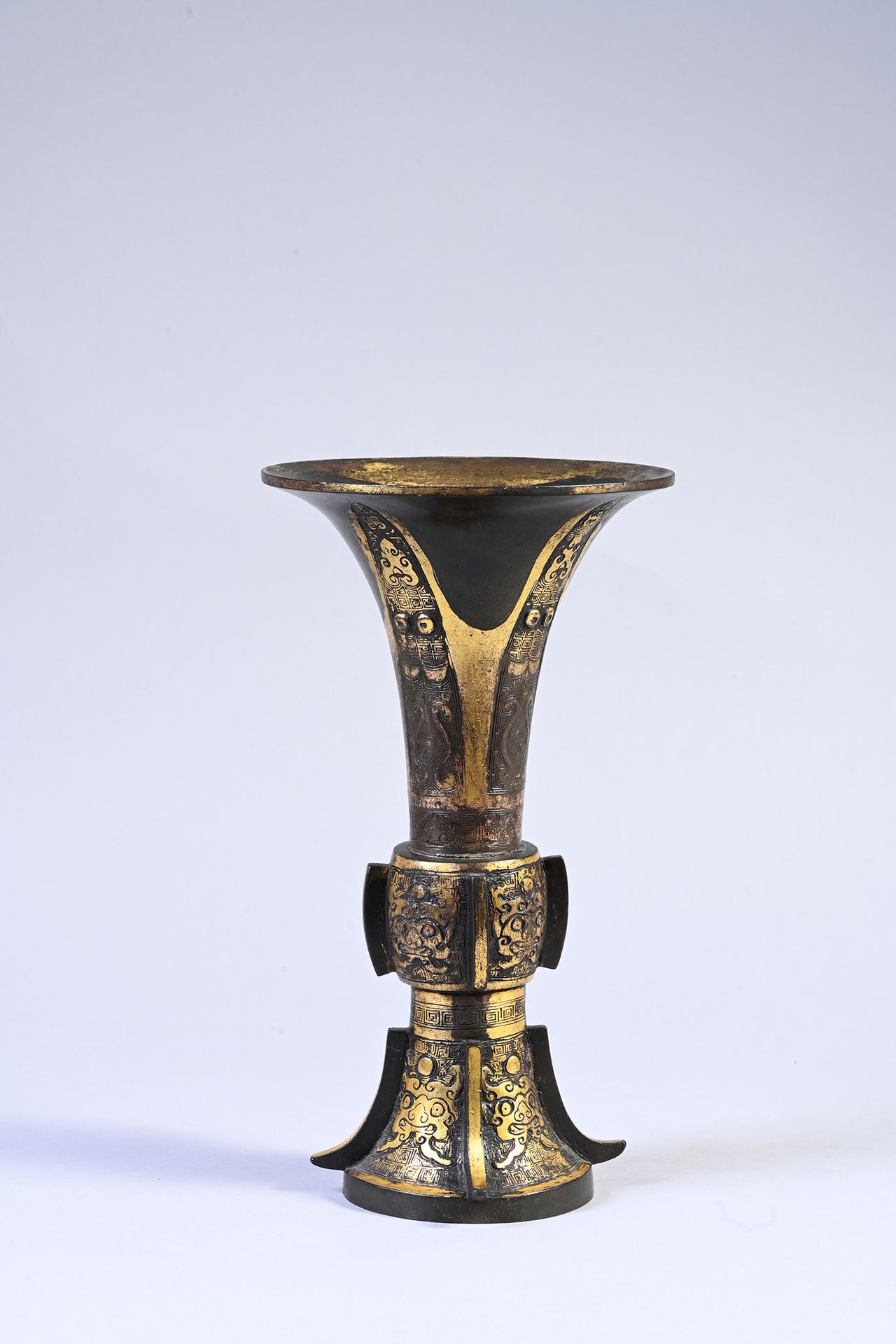 CHINE, XVIIe siècle 一个部分镀金的青铜花瓶
根据古代的 "古 "餐具模型，加大的底，小的中间体，长的外翻的颈部，两边有肋骨，刻有饕餮面具、雷&hellip;