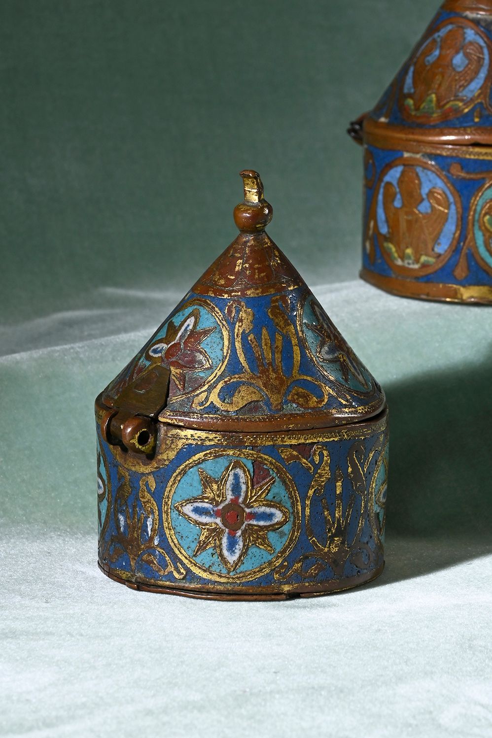 Null 一件深拉、夹层、珐琅、雕刻和镀金的铜制貔貅，中蓝、绿松石、红和白珐琅上装饰着放射状的四叶形圆盘和叶子，圆锥形的盖子上有一个球形的顶。
利摩日，13世纪&hellip;