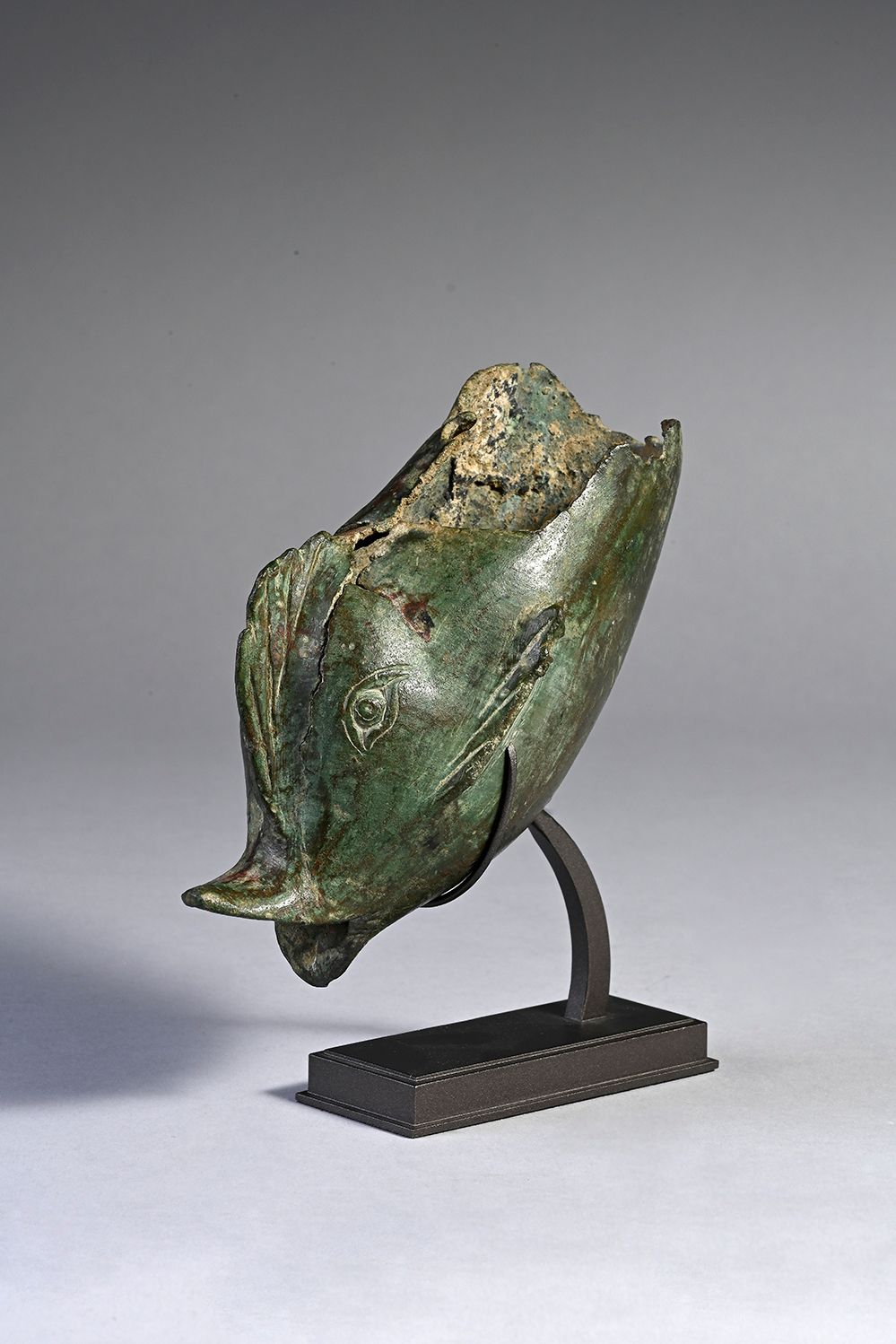 Null 残缺不全的雕像，代表了一个风格化的海豚的前半部分。它可能是维纳斯雕像的一部分。青铜器。绿色氧化。罗马艺术。L. 16 cm.