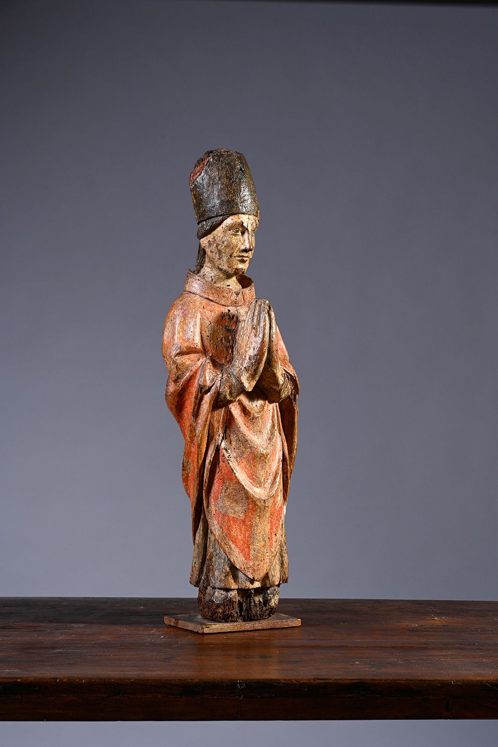 Null 胡桃木圆雕和多色雕刻的圣主教。他戴着手套，双手合十站立，戴着露珠落在背上的斜塔，前面是带着圆形褶皱的披肩。
15世纪初
H.75厘米
(下部缺失，有裂&hellip;