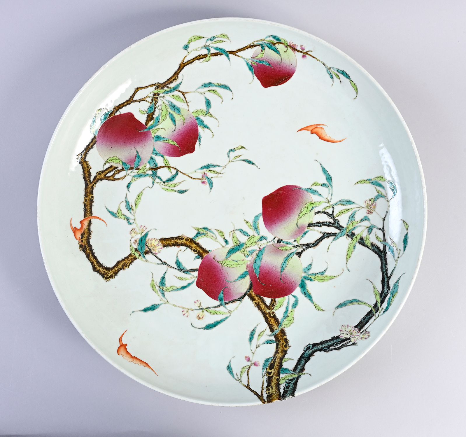 CHINE, Marque et époque Guangxu, XIXe siècle 圆壁大瓷盘，白地粉彩绘有优雅的两枝桃花，由三只铁红处理的蝙蝠飞过，还有&hellip;