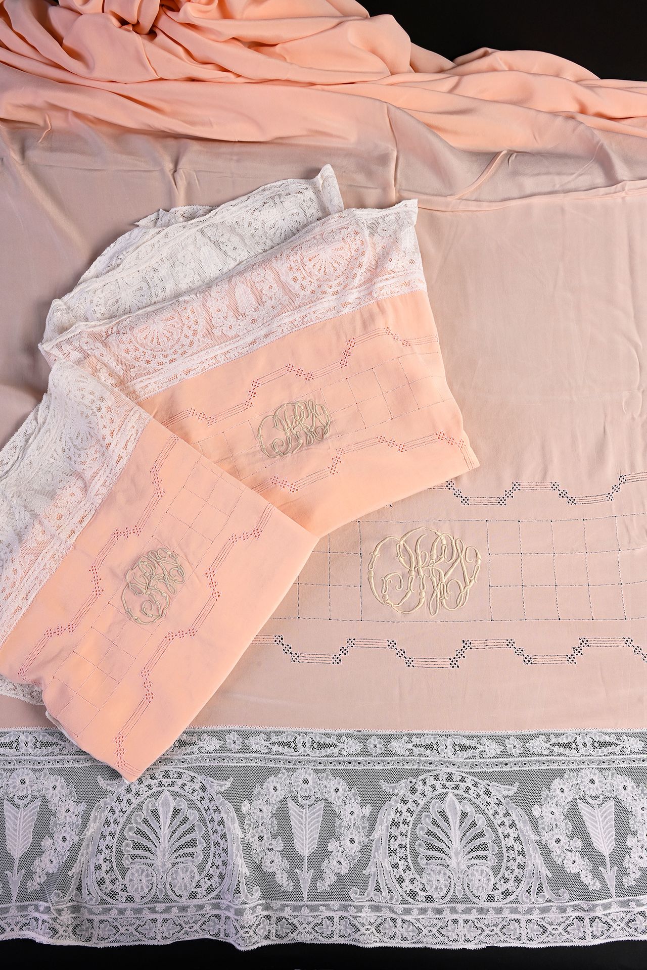 Null 丝绸和蕾丝床品套装，床单和枕套，20世纪初。
这套完整的杏色丝绸床品包括带回纹的床单和两个配套的方形枕套以及下面的平板床单，上层床单带大回纹，绣有非常&hellip;