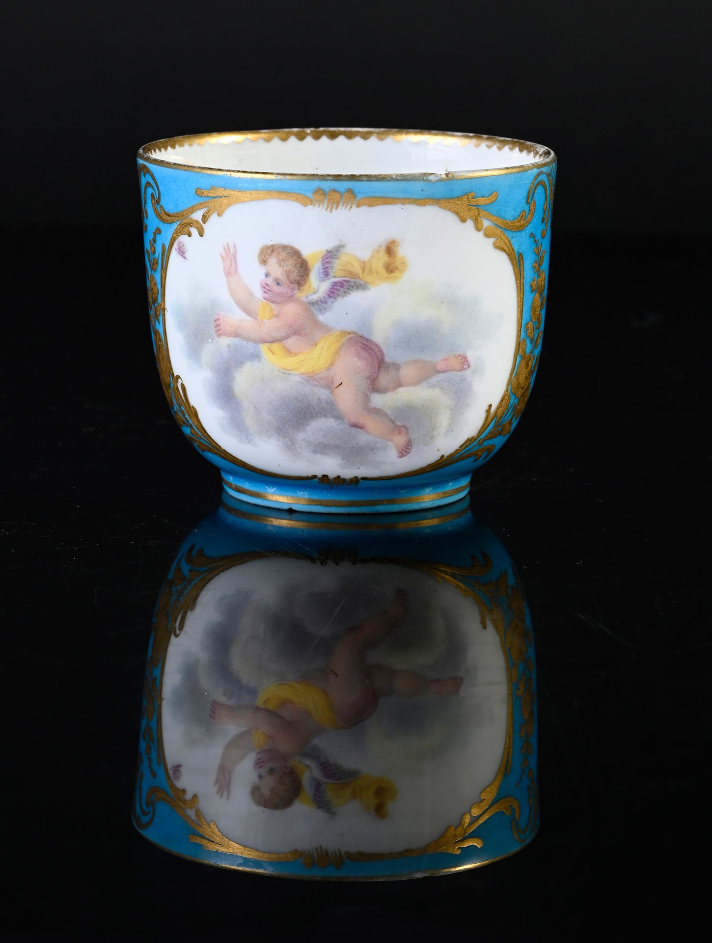 Null 18世纪塞夫勒瓷器 "Bouillard "杯（第一尺寸），过度装饰
蓝色的两个交错的L的伪标记
天蓝色背景上的多色装饰，一个在云中的普托，一个金色的&hellip;