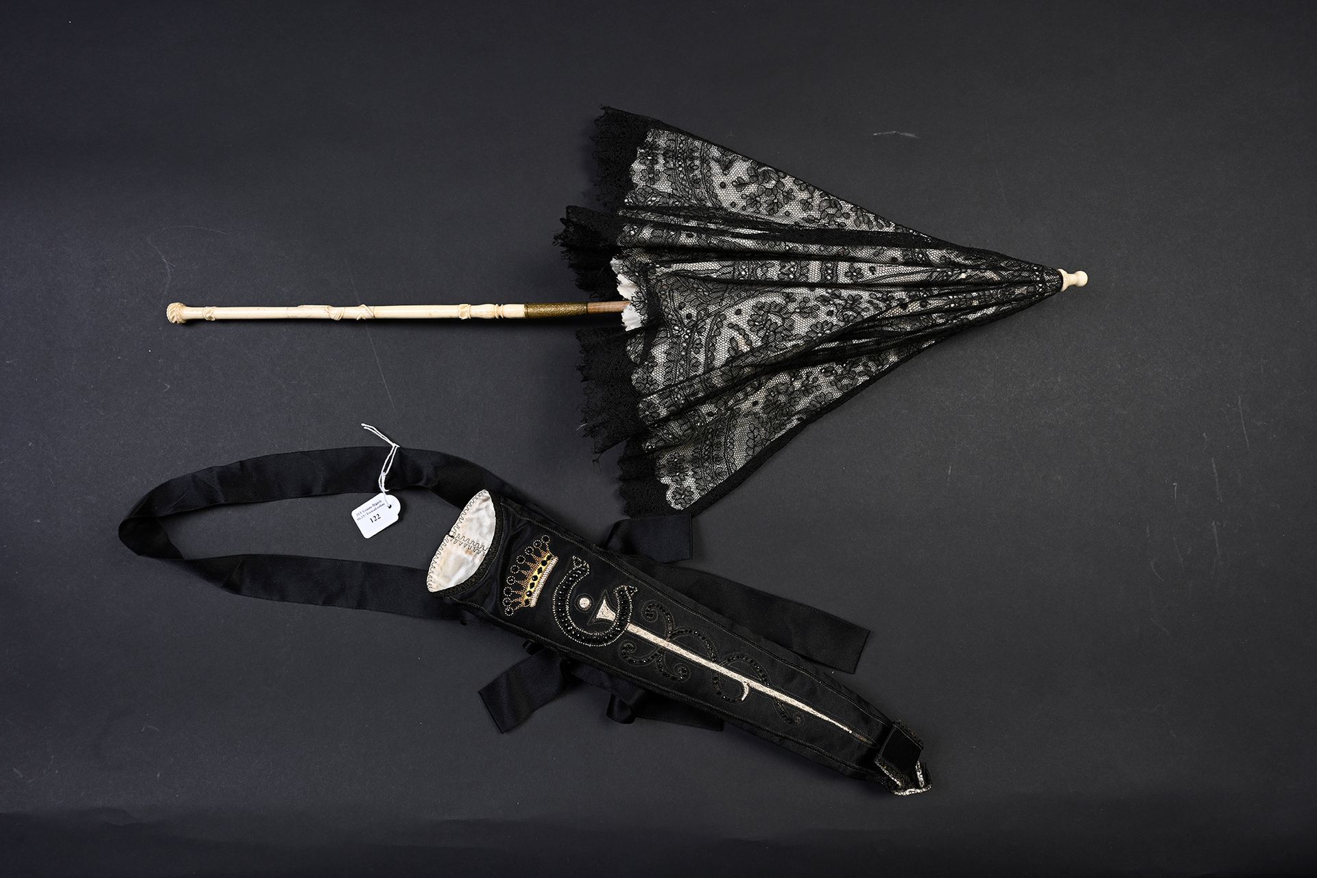 Null 遮阳伞，欧洲，约1860年
黑色波纹花边，内衬奶油色丝绸。
雕刻的骨质手柄。折叠。
H.63厘米（撕裂）。
保存在其罕见的黑色缎子箱子里，绣有数字 "&hellip;