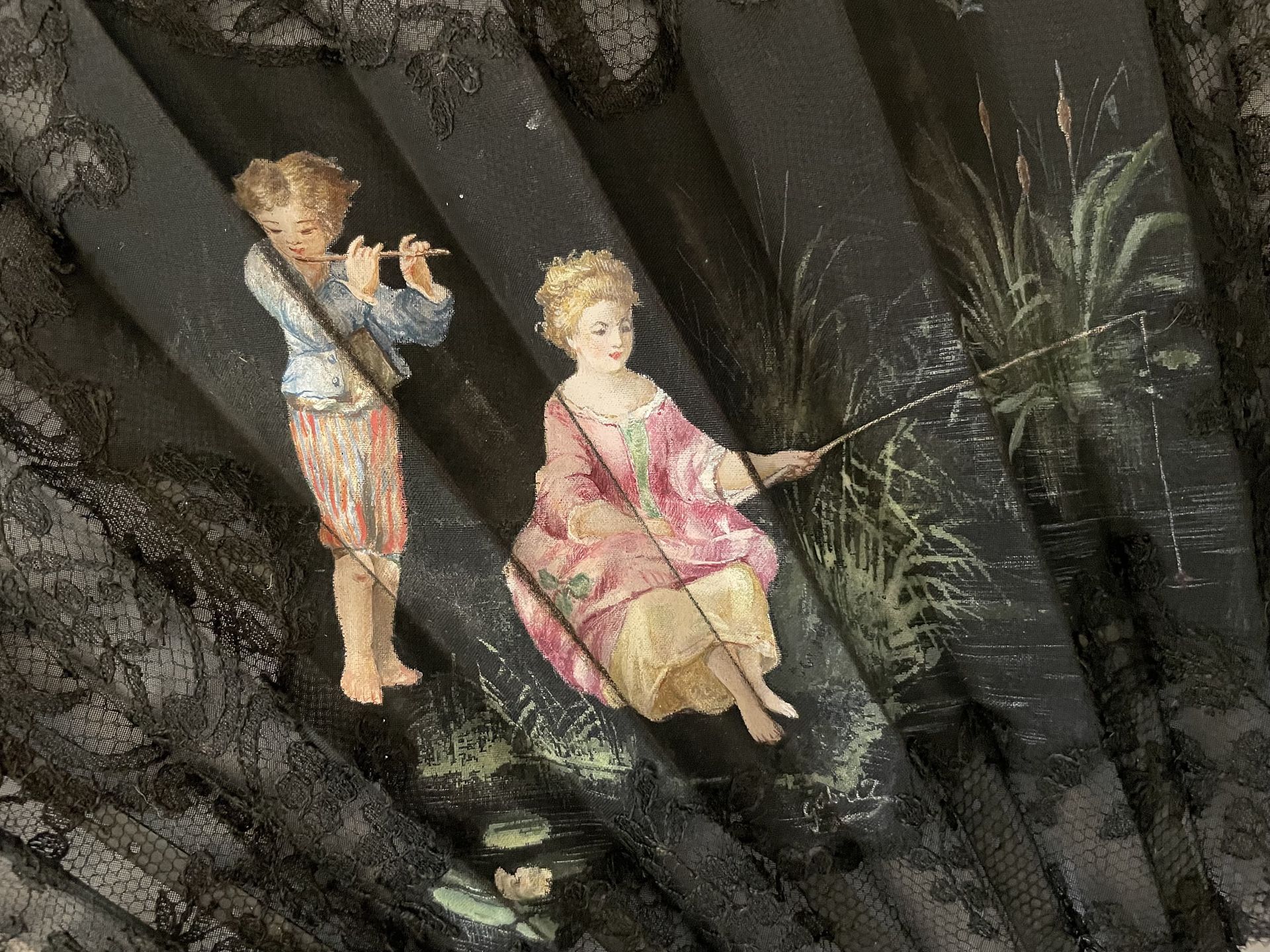 Null 两个孩子，欧洲，约1890年 
折扇，黑色的花边叶子上装饰着花朵，画着两个在水边的小孩子，在一个卡特尔中。签名为 "Gabril (?)"。哑的背面。&hellip;
