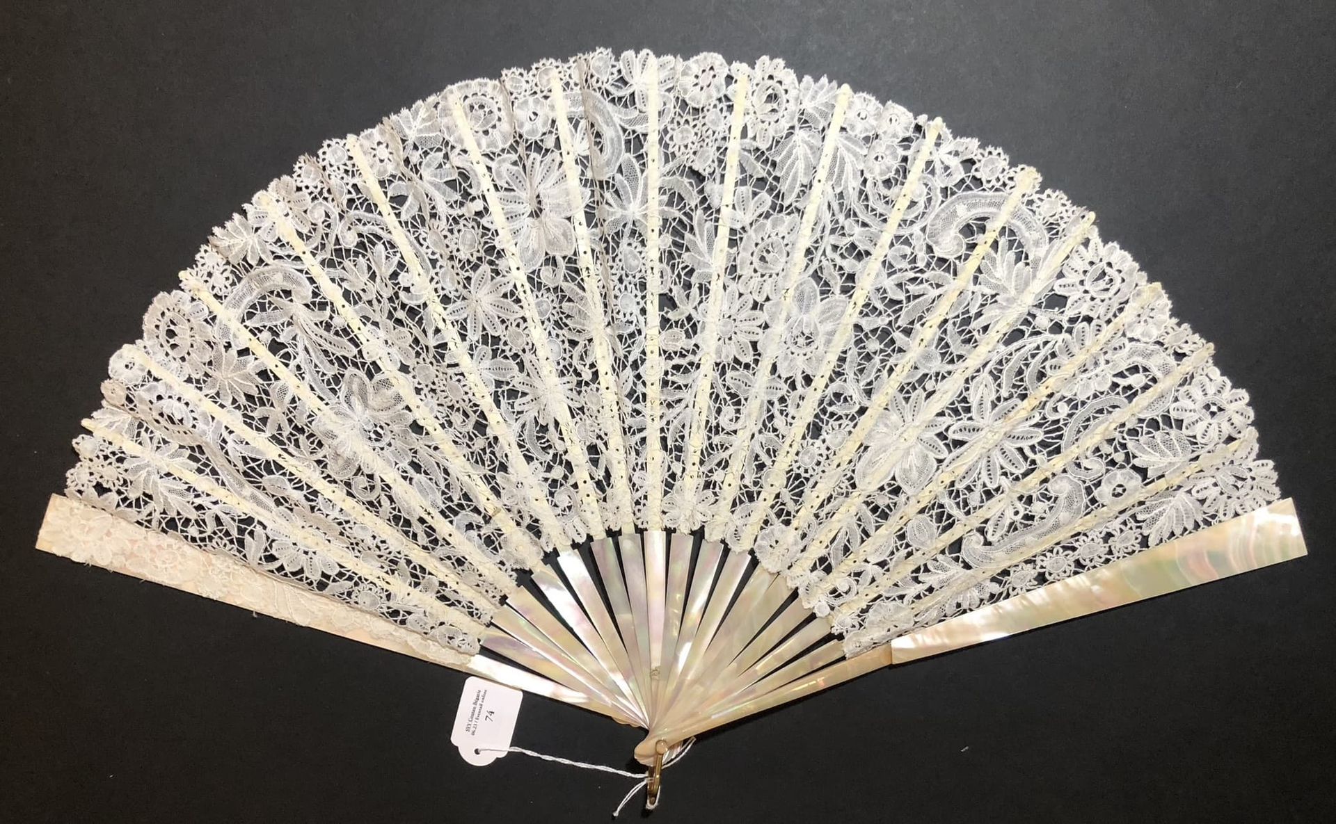 Null 白色蕾丝，欧洲，约1890年
折叠的扇子，叶子是由白色波纹花边制成的，有花朵装饰。
珍珠母的布尔高框架。金属吊架。
高约。32,5厘米（意外）