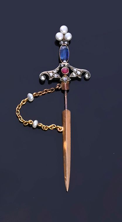 Null 18K（750 年）金和 800 年银别针，造型为一把剑，剑柄上镶嵌着一颗蓝宝石和一颗玫瑰式切割钻石镶嵌的红宝石，顶端有 3 颗钮扣珍珠，剑鞘由一条 &hellip;