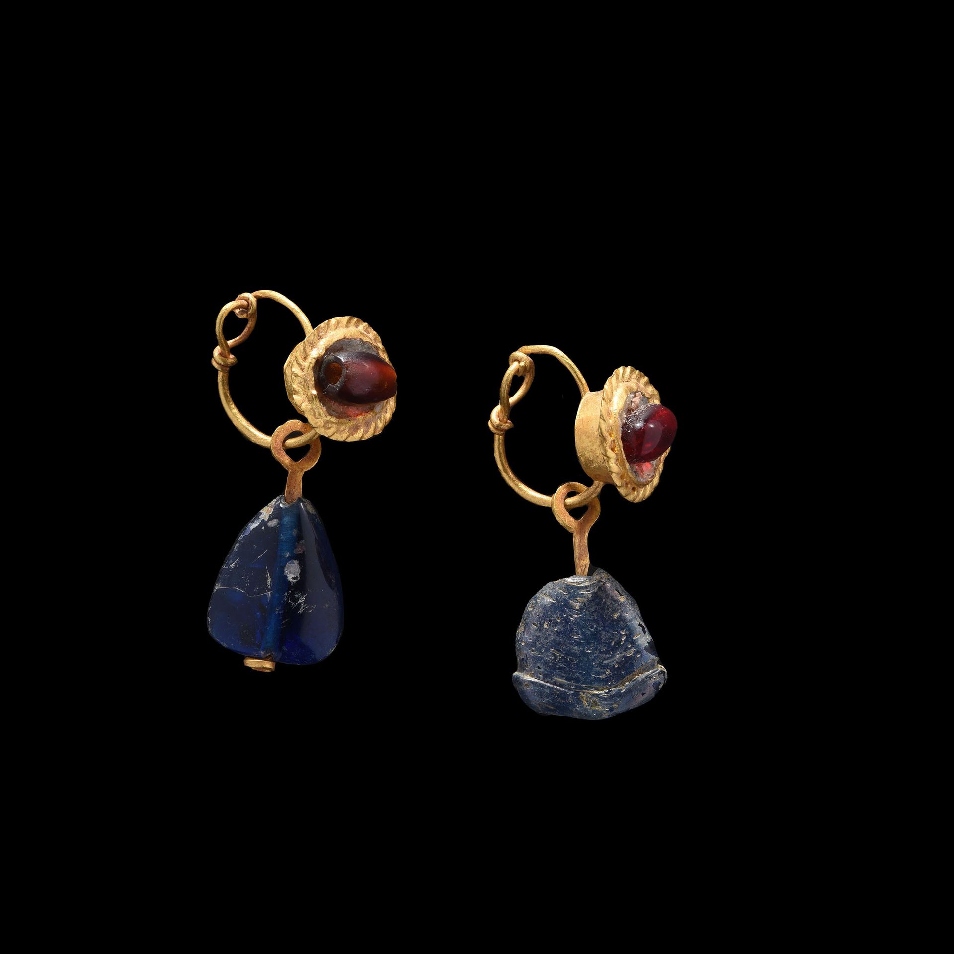 Null 耳环一对

1-2世纪的罗马艺术。

镶嵌石榴石和蓝色玻璃珠的黄金。

H.30毫米



出处

前L先生的私人收藏，列于1982年7月的一份清单中&hellip;