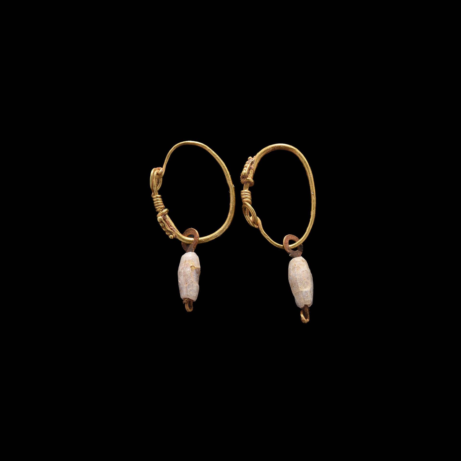 Null 耳环一对

罗马艺术，1-2世纪。

由黄金制成，有一个单环，末端变细，缠绕在一个钩子上。扣件上装饰有一个带金珠的三角板。带有白色彩虹色玻璃珠的Pen&hellip;
