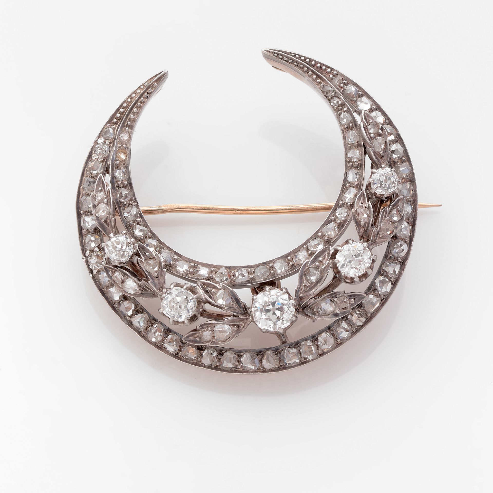 Null 月牙形胸针

黄金和银质新月形胸针，镶有玫瑰式切割钻石，中心为叶子图案，并装饰有老式切割钻石。

19世纪。

有大师级印记的痕迹，有编号。

一枚玫&hellip;
