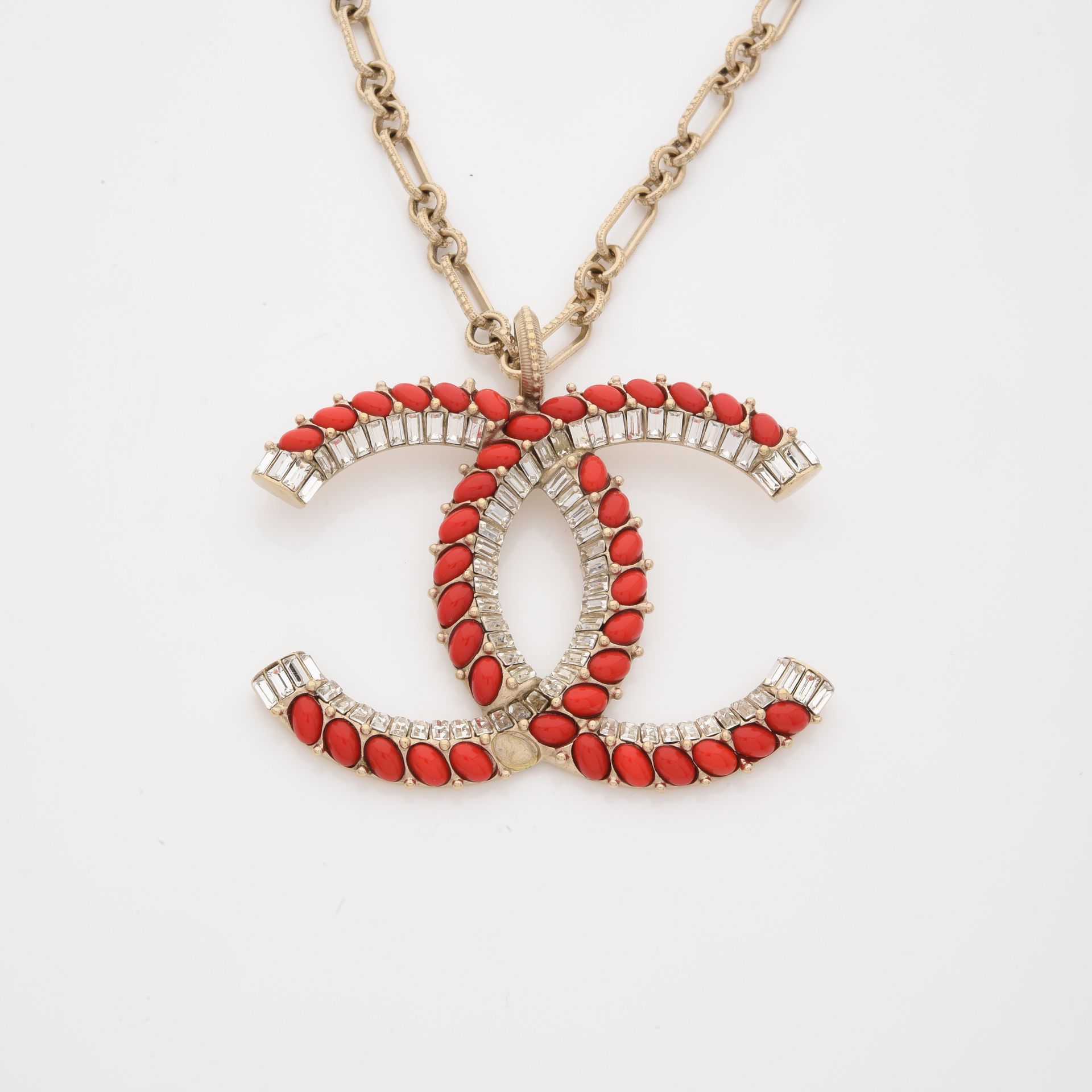 Null 香奈儿

镀金金属链项链，上面有一个大的标志吊坠，用长方形水钻和红色珐琅凸圆形宝石加强。

(缺少一颗凸圆形宝石)