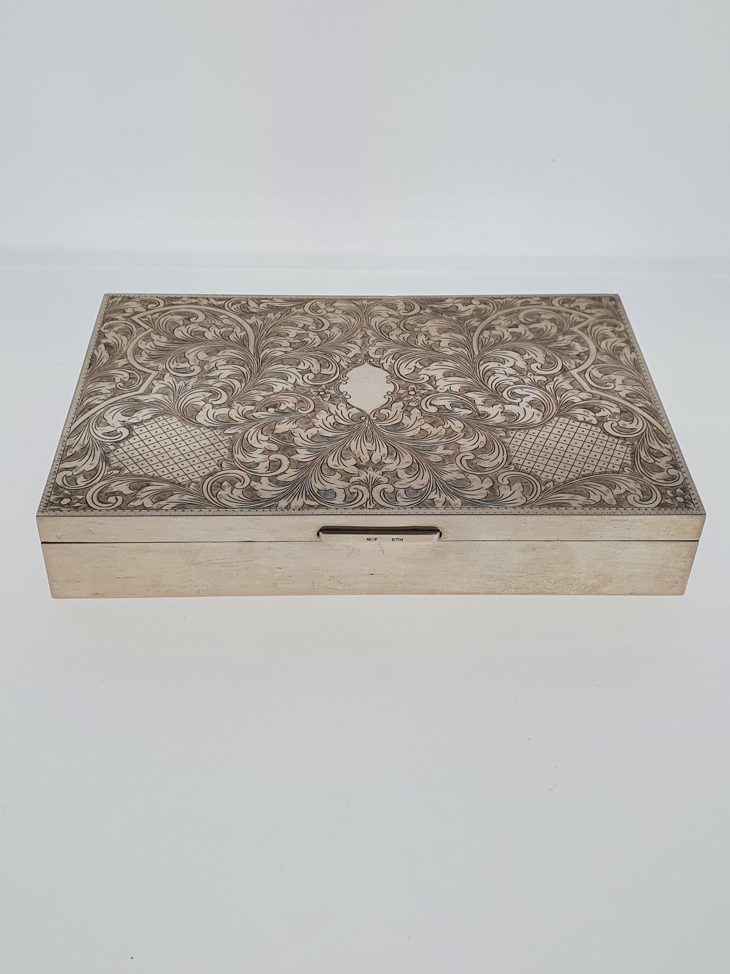 Null 一个镀银的木箱，露台上装饰着树叶和卷轴。

标题800

20世纪

高度：3.5厘米

20 x 13厘米