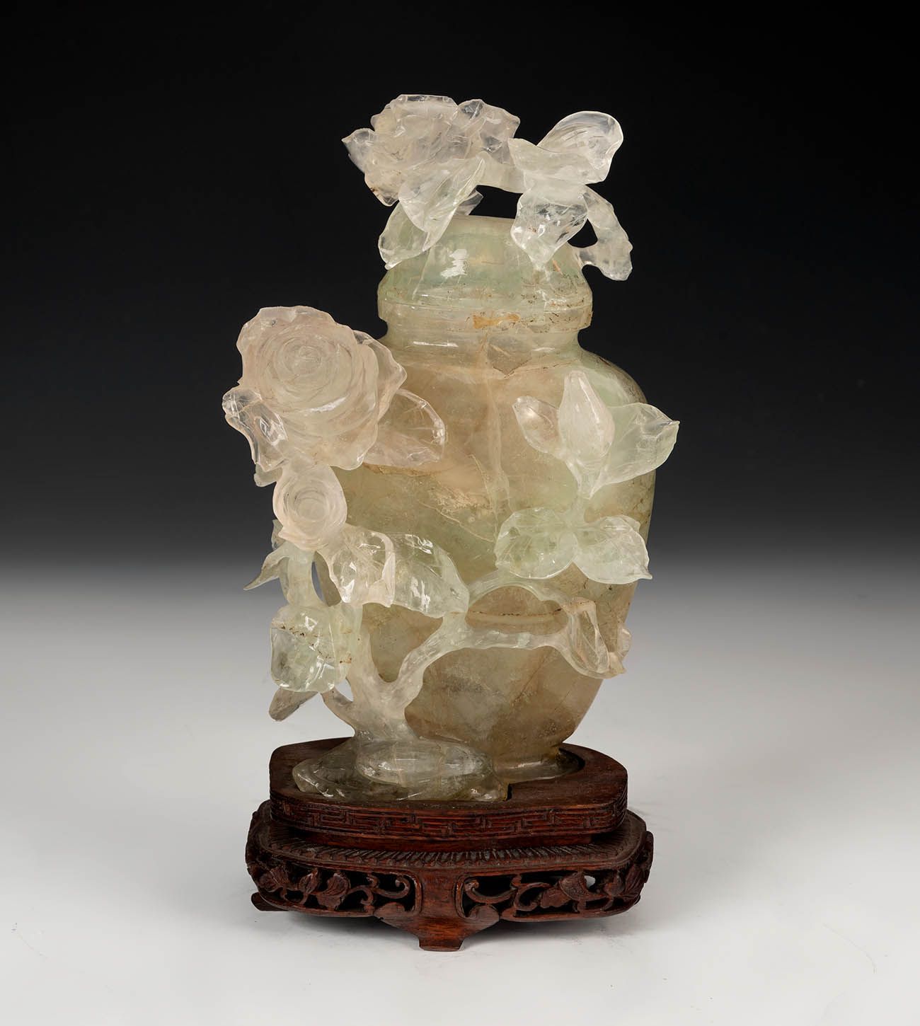 Null 有花的陶器。中国，20世纪。
木质底座上手工雕刻的萤石。
尺寸：16厘米（高）；3.5厘米（底）。
壶中有精雕细琢的半透明玉石，装饰有玫瑰花。它矗立在&hellip;