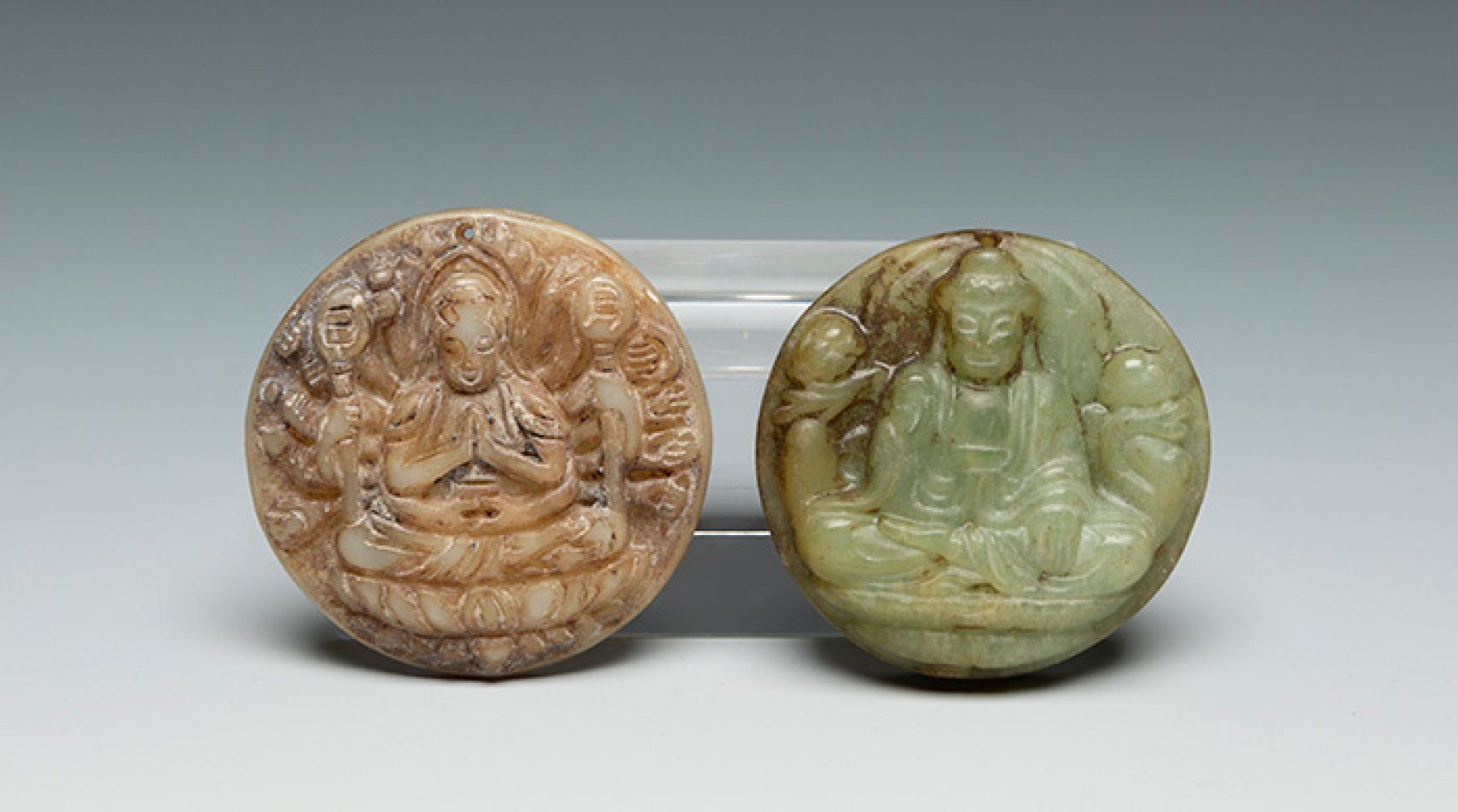 Null 一对佛像奖章。中国，19世纪。
各种玉石。
测量。5厘米（直径）。
一对中国的浮雕佛像，代表了两尊佛。佛陀达到了最大的进化完美，他为众生化苦为乐。他生&hellip;