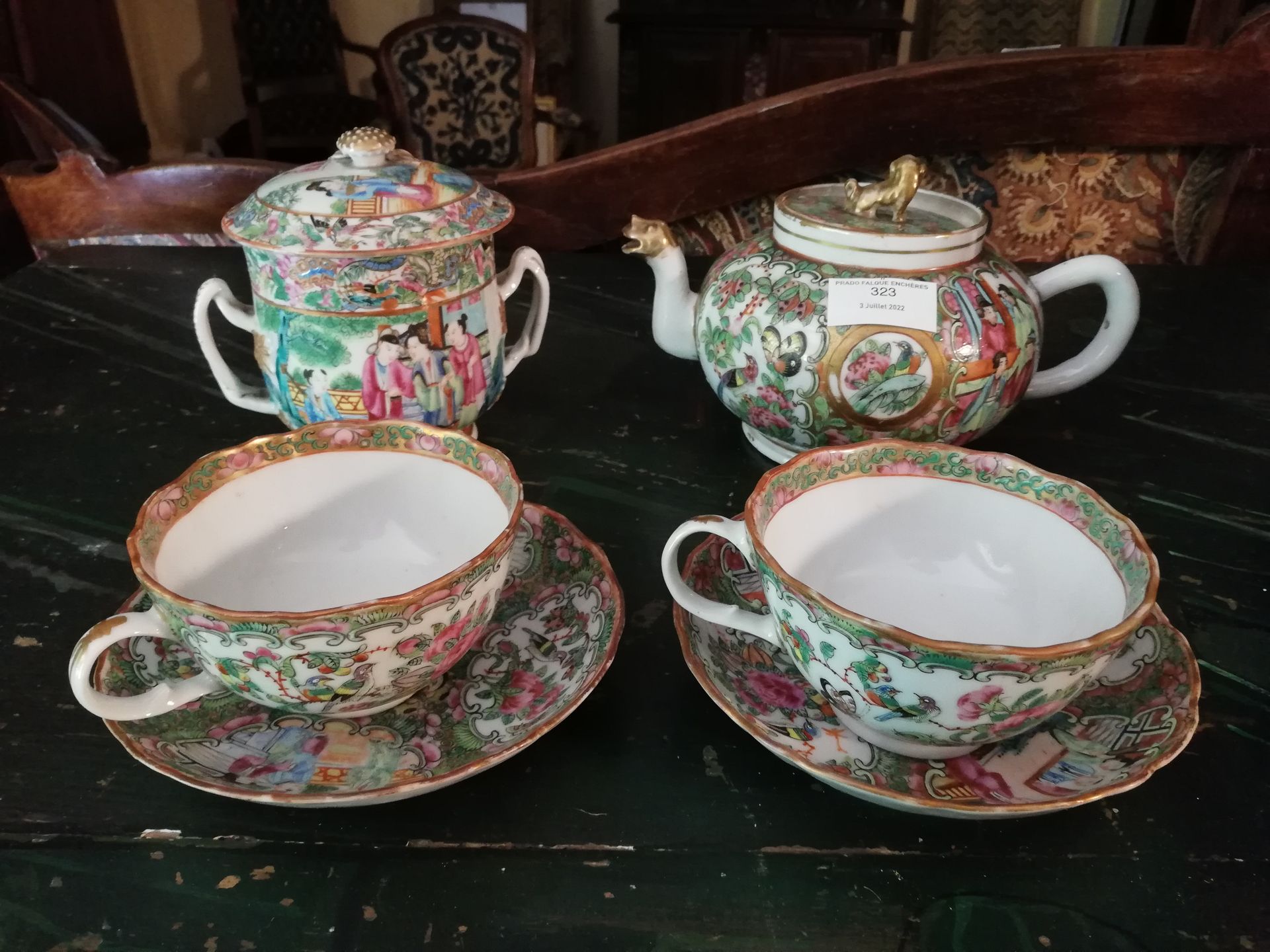 Null 中国，广东瓷器茶具的一部分，有宫廷场景装饰，由两个杯子和它们的茶托（一个杯子有裂缝），一个糖碗和一个茶壶组成。