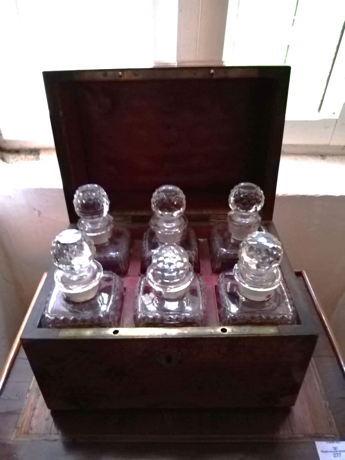 Null 木质贴面的酒柜。内部显示了6个水晶酒壶（损坏和丢失的部分）。19世纪。23x29x20厘米