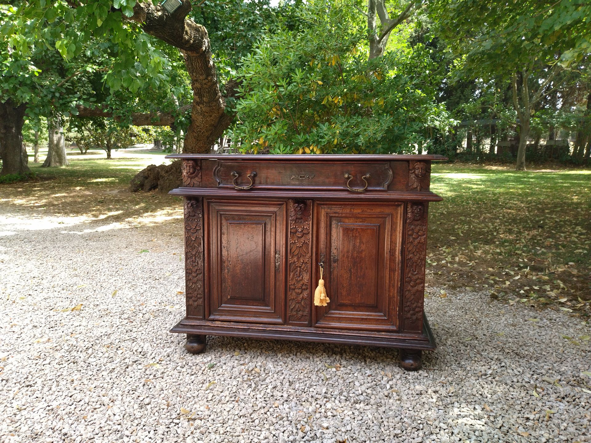 Null 一个模制和雕刻的胡桃木边柜，腰部有一个抽屉，两扇门上装饰着面具、叶子和水果。XVII时期（恢复使用）。96x121x59厘米