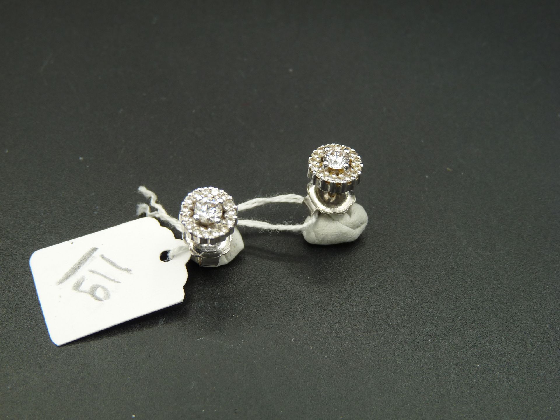 Null 一对 18K （750/oo）白金耳钉，每对耳钉都以一颗约 0.17 克拉的明亮式切割钻石为中心，周围镶嵌较小的钻石。总重量：3.4 克。