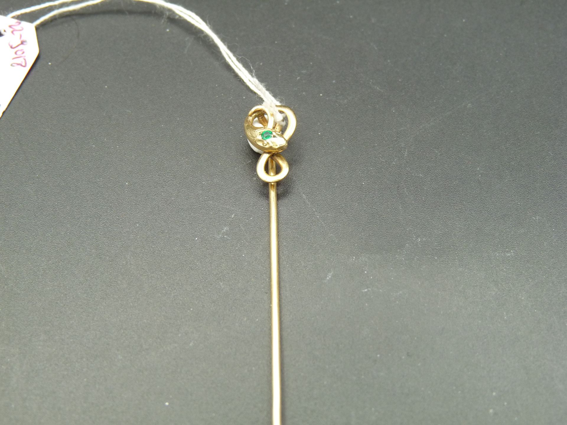 Null 镀金金属领带夹 (FIX) 上有一条蛇，蛇头上镶有一颗绿色宝石。