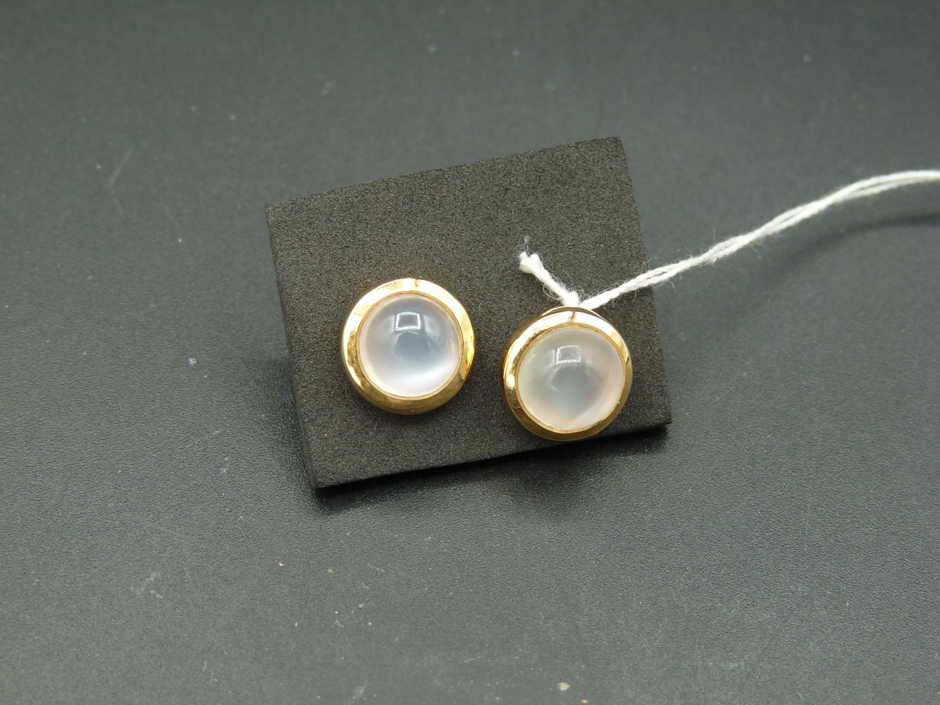 Null 一对 9K 黄金耳钉（375/oo），每个耳钉都镶嵌一颗凸圆形月光石。毛重：3.7 克。