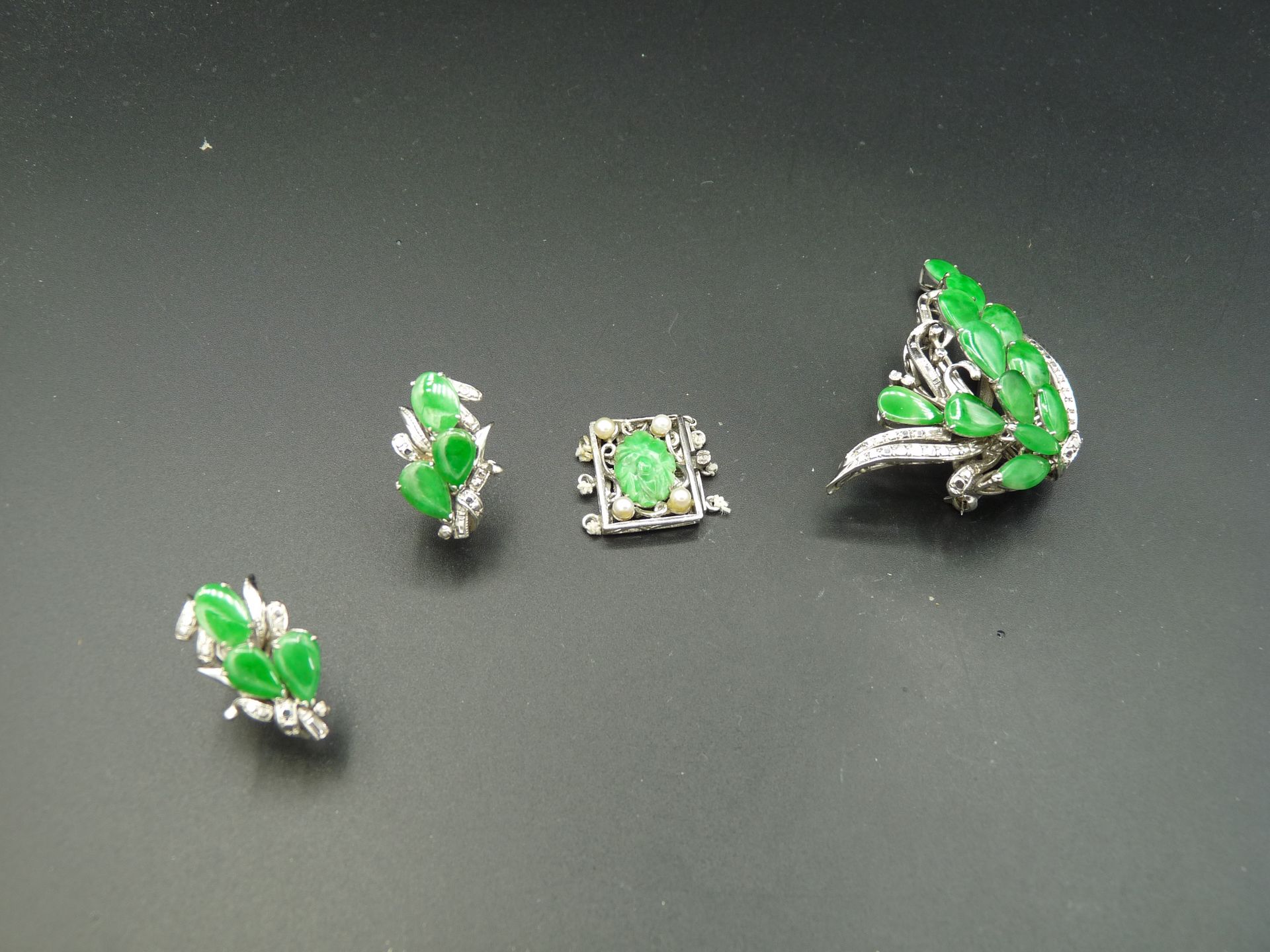 Null 一套镀银首饰，包括一对螺旋式耳环、一枚吊坠胸针和一条三排项链/手镯扣，镶嵌绿色梨形、椭圆形和尖顶形（有色玉石？亚洲作品。