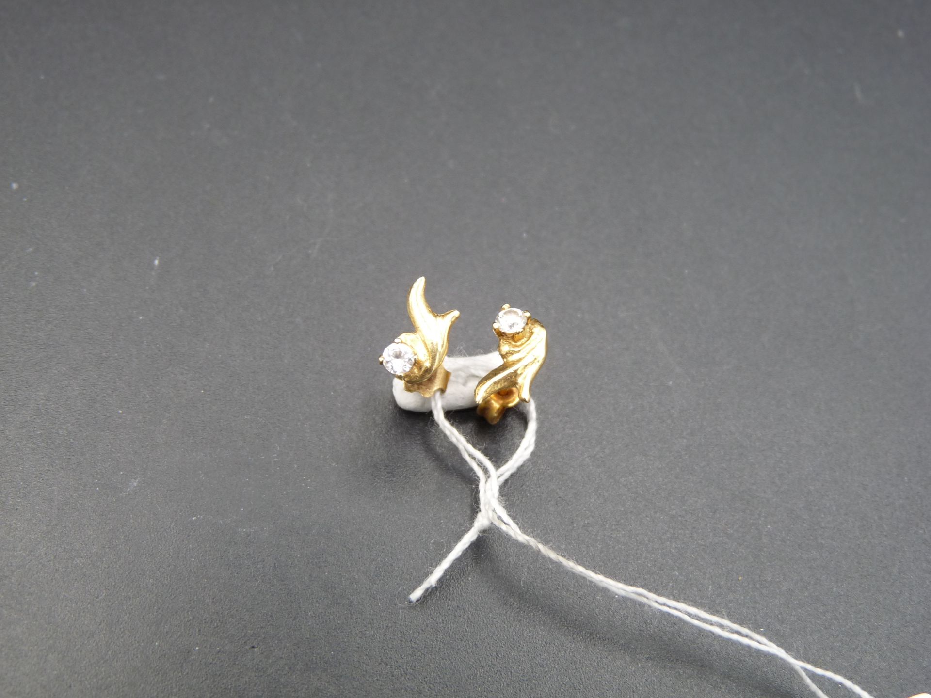 Null 一对 18K （750/oo）黄金耳钉，各镶嵌一颗仿白宝石。高度：约 8 毫米。毛重：0.6 克。