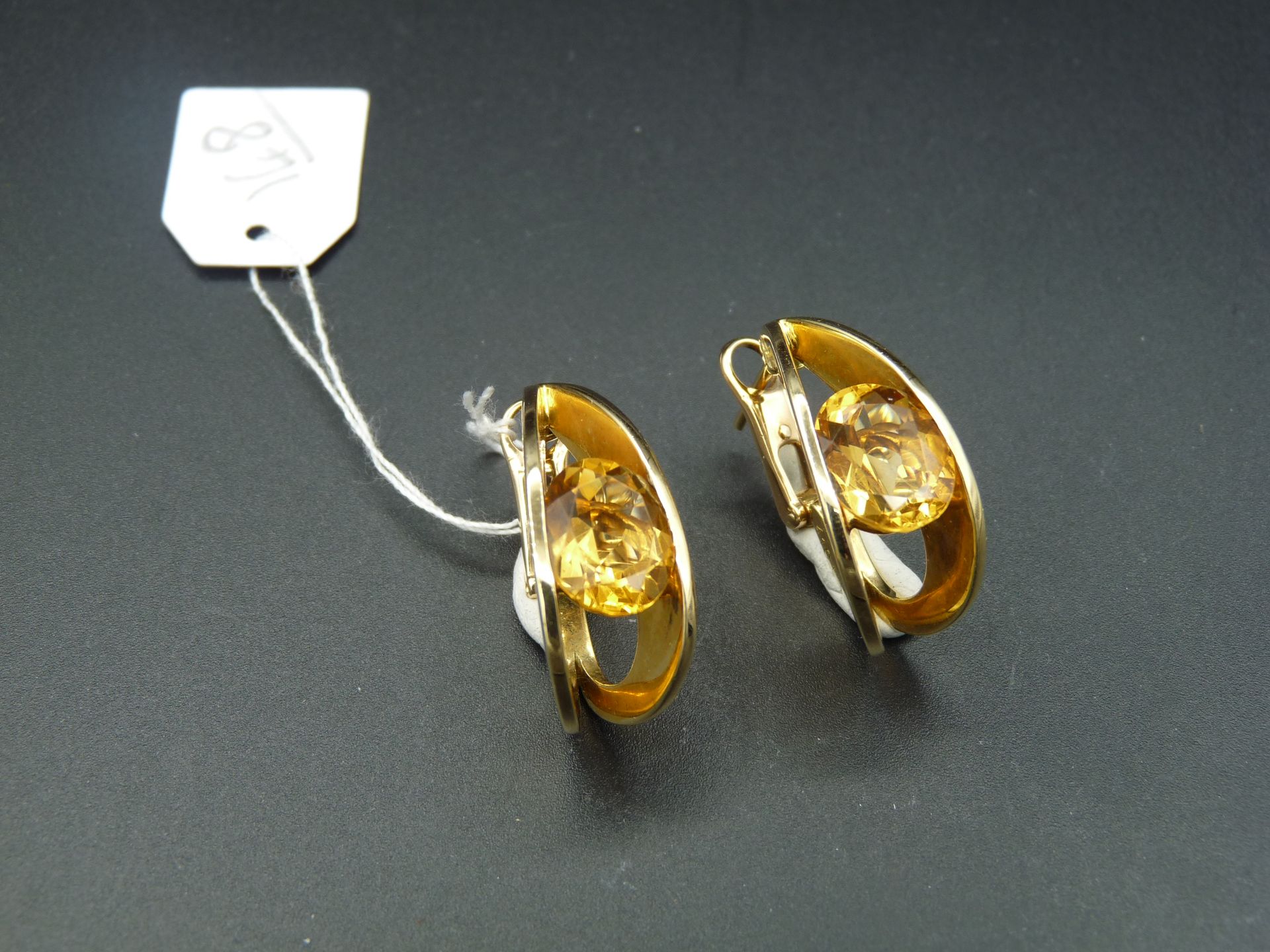 Null 一对光滑的 18K （750/oo）黄金耳夹，饰有镂空楔形花纹，每个耳夹都以一颗椭圆形黄水晶为中心。高度：约 27 毫米。其中一个带有库存编号和克里斯&hellip;