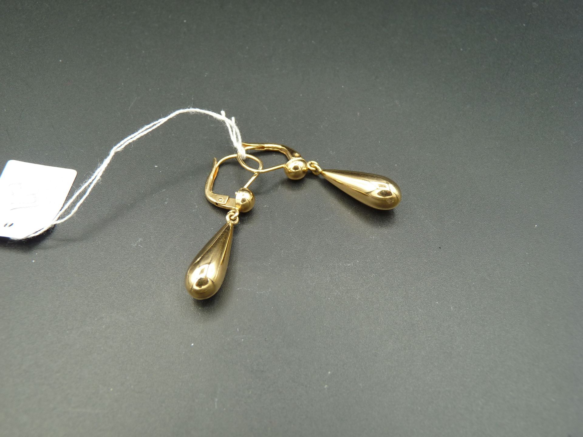 Null 一对光滑的 18K （750/oo）黄金耳环，每个耳环都由一个固定空心坠子的枕形夹组成。 高：约 36 毫米。毛重：3.7 克。