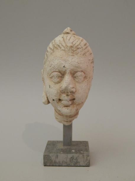 Null Tête de femme en stuc. H : 8 cm. GANDHARA (1er - 5e siècle)