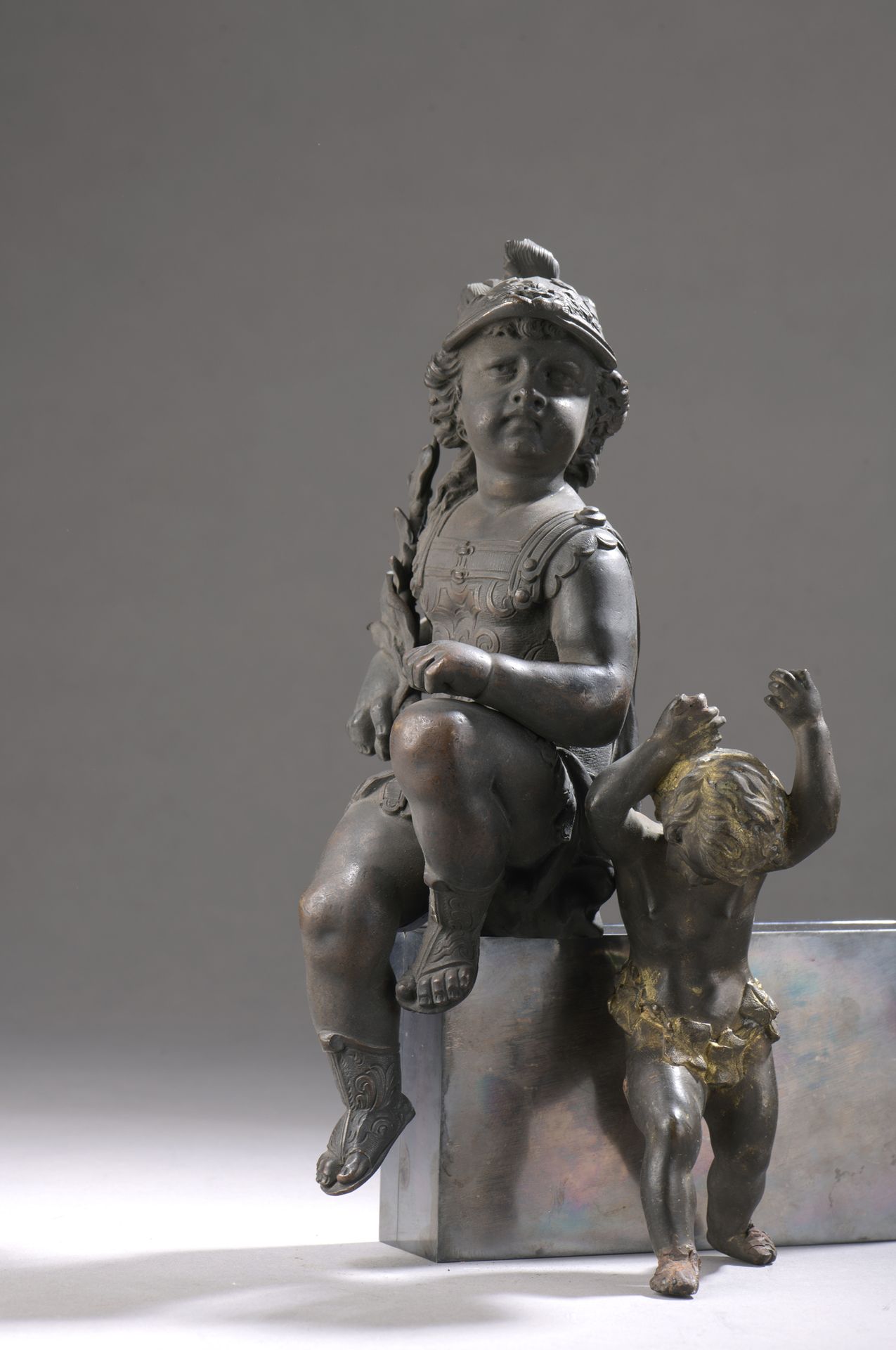 Null 一件带有金属光泽的青铜雕像，展示了一个带着头盔和盔甲的孩子，具有罗马风格，是战争的象征。

路易十四风格。19世纪末。高27,5厘米

一个小的木制支&hellip;