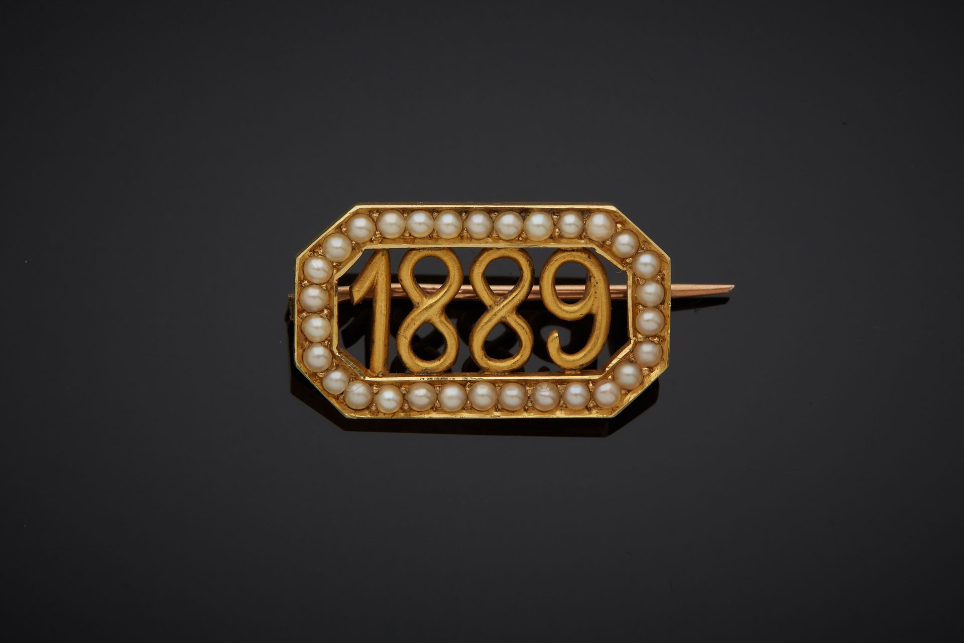 Null 一枚18K黄金750‰胸针，长方形镂空造型，刺有1889年的日期，周围有半珍珠。14K金针585‰。

尺寸：1.30 x 2.20 cm 毛重：3.&hellip;