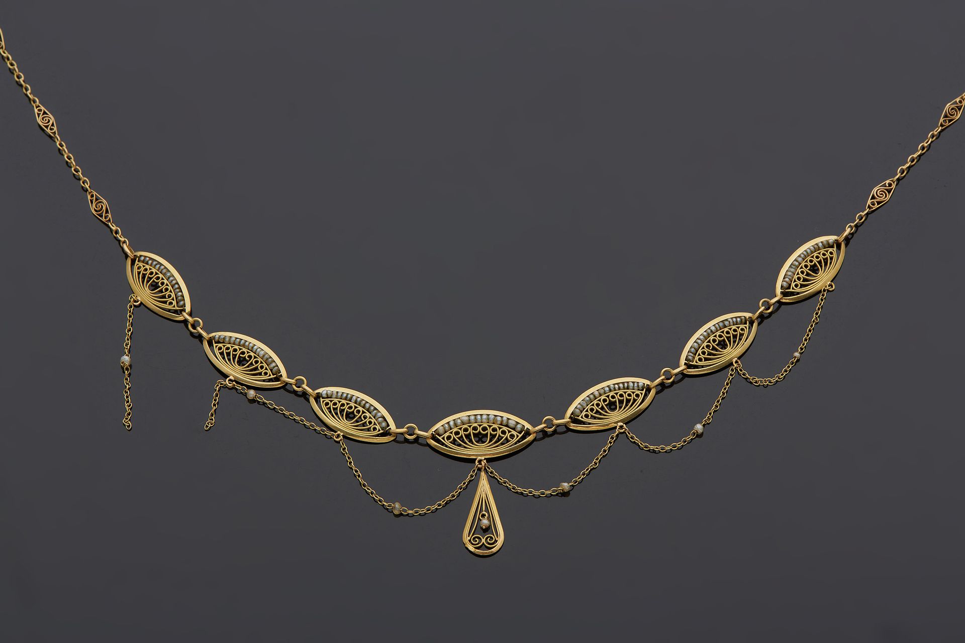Null 一条18K黄金750‰的花丝垂坠项链，上面装饰着珍珠。有一条链子要重新缠绕。

长38厘米 毛重7.80克