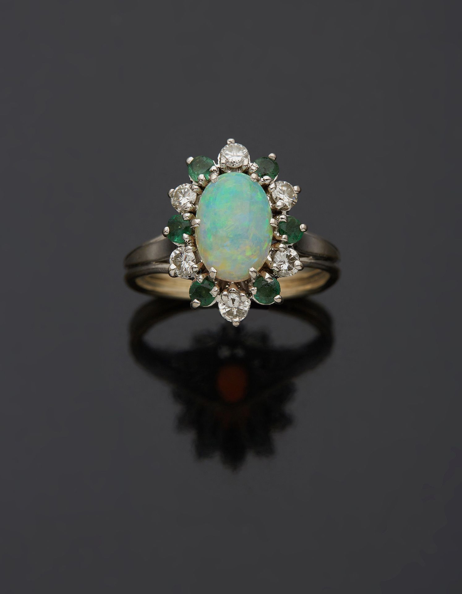 Null 一枚18K白金750‰的戒指，在祖母绿和明亮式切割钻石的交替环绕中镶嵌着一颗蛋白石。闪闪发光的石头。

手指尺寸53 毛重4.50克