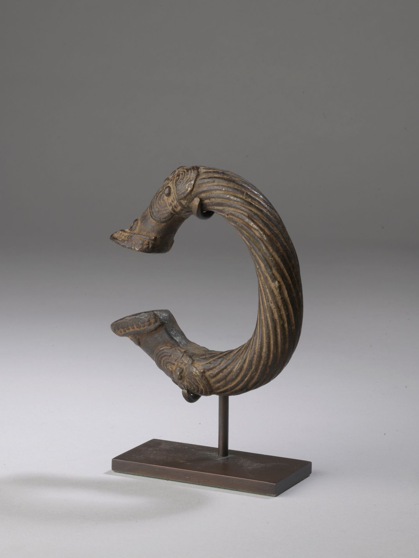 Null 手镯 SENOUFO, 象牙海岸

铜合金。

D. 8,5 cm

开放式手镯，扭曲的主体在两端装饰有风格化的蟒蛇头。