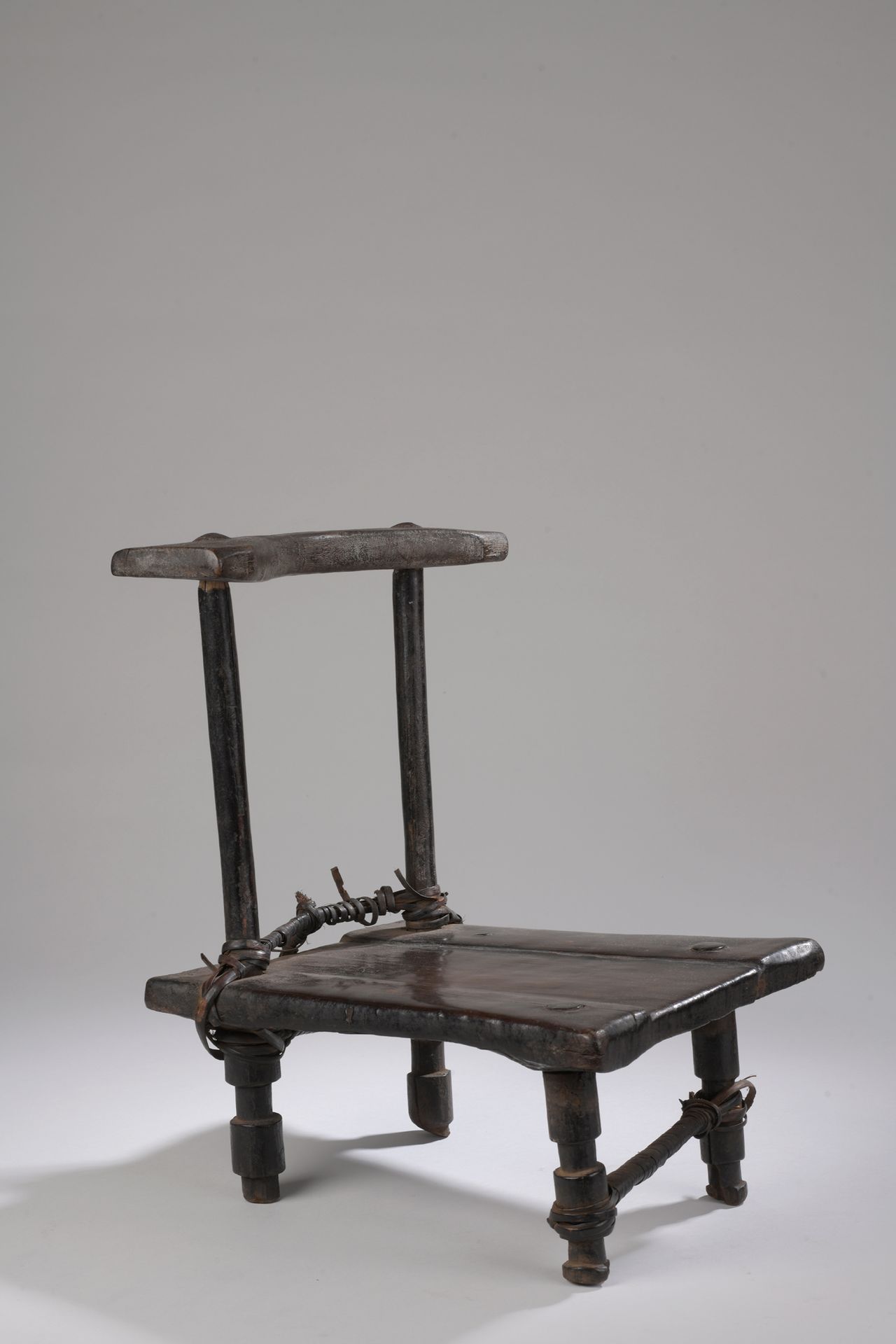 Null GREBO KROU主席，象牙海岸 

带有深棕色铜锈的木材，柳条。

H.41 W. 33 cm

这把小椅子上有美丽的古铜色，座位长于宽。