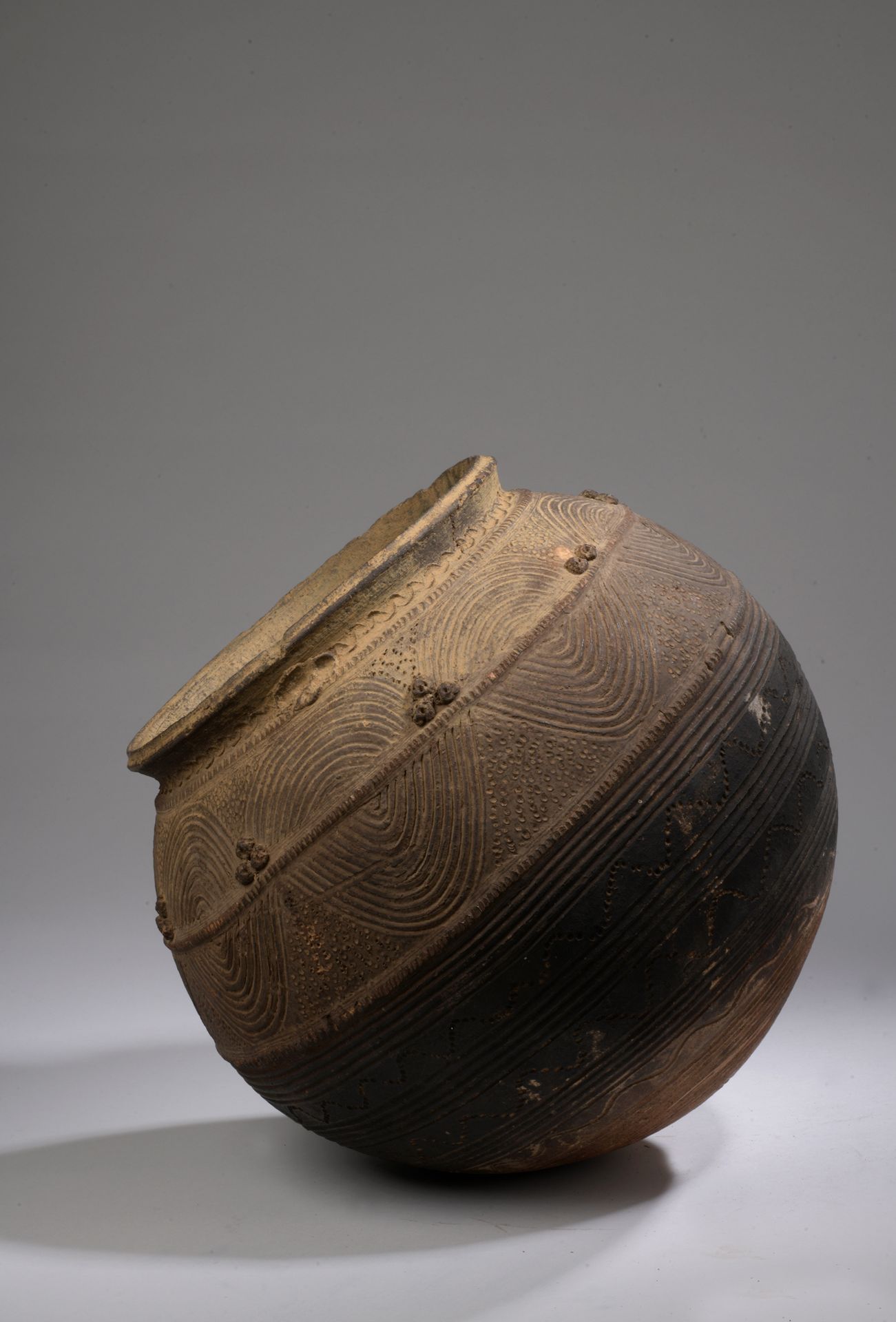 Null NUPE JARRE, 尼日利亚

陶器，带棕色滑石。

H.34 D. 32 cm

球体上装饰着丰富的几何图案，滑面有三种交替的色调。