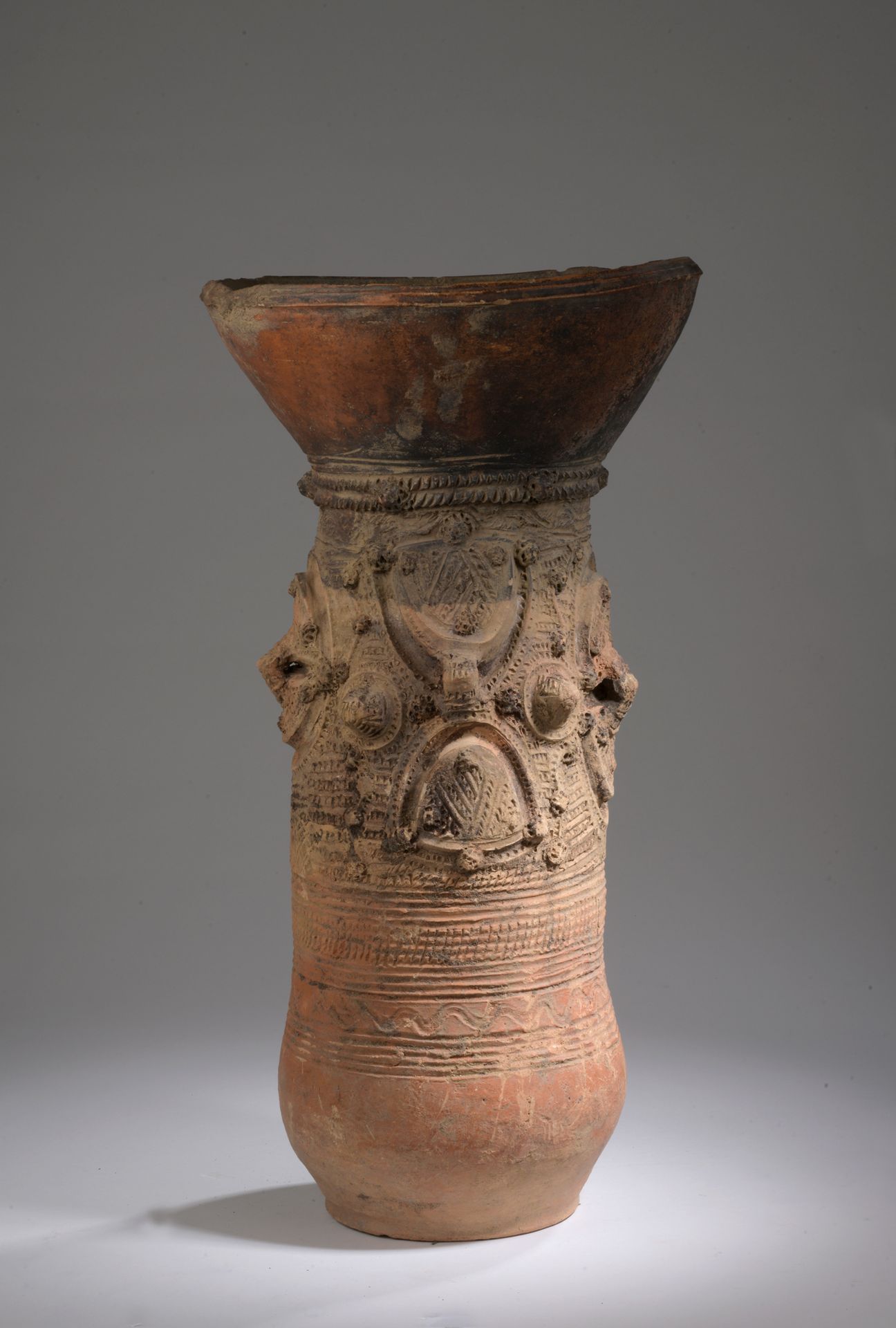 Null ETSO NUPE储物罐, 尼日利亚

陶器与赭石和红赭石滑石

H.60 D. 31 cm

喇叭形的颈部套在一个圆柱形的轴上，上面有塑料的装饰。
&hellip;