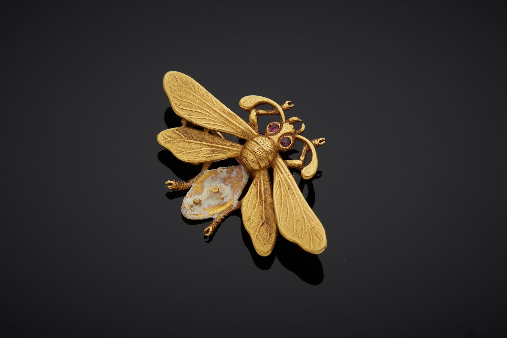 Null 一枚18K黄金750‰胸针，为蜜蜂造型，眼睛为红色宝石，腹部的装饰物缺失。

长3,90厘米 毛重4,70克