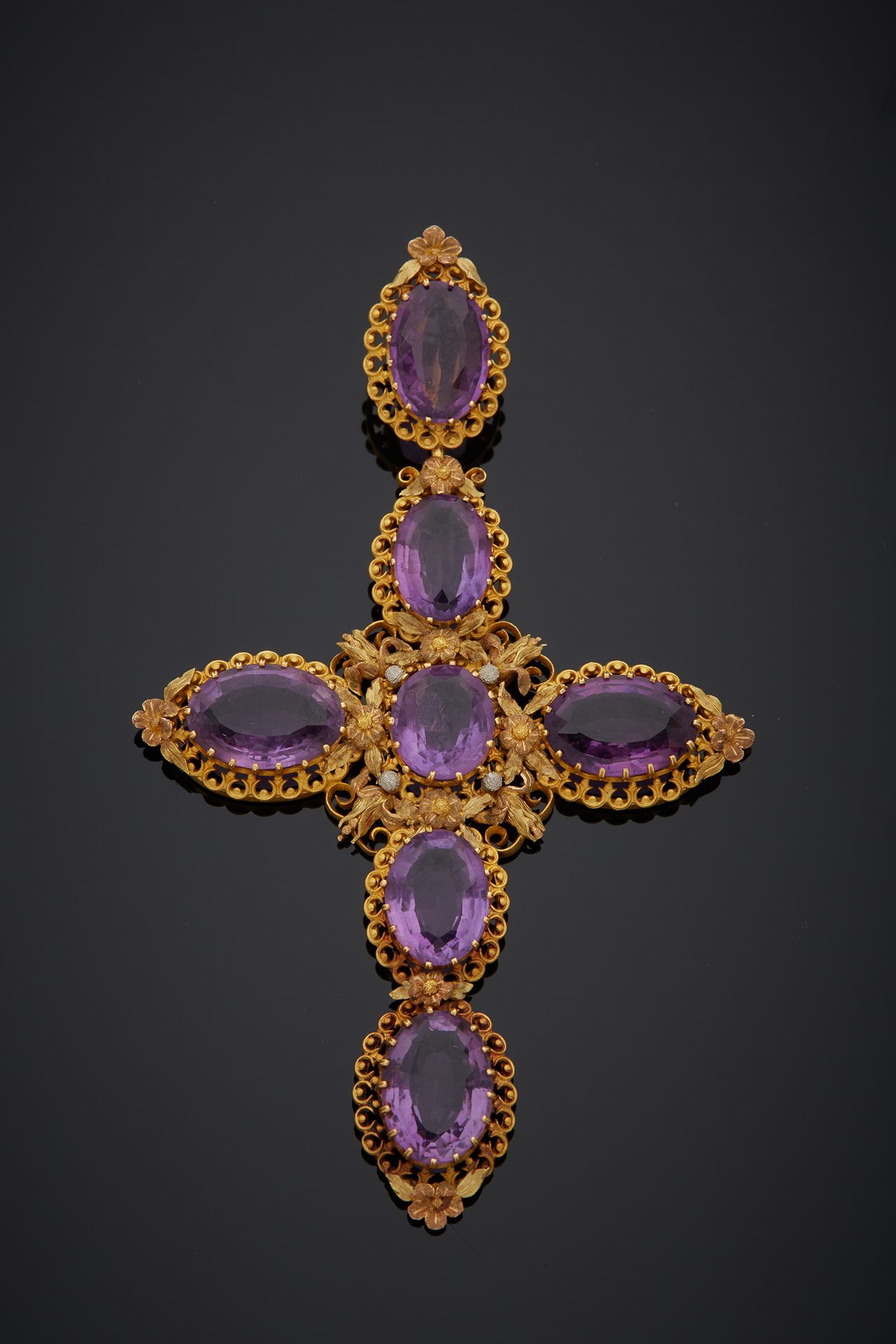Null A polychrome 18K gold 750‰ cross, with floral decoration, set with amethyst&hellip;