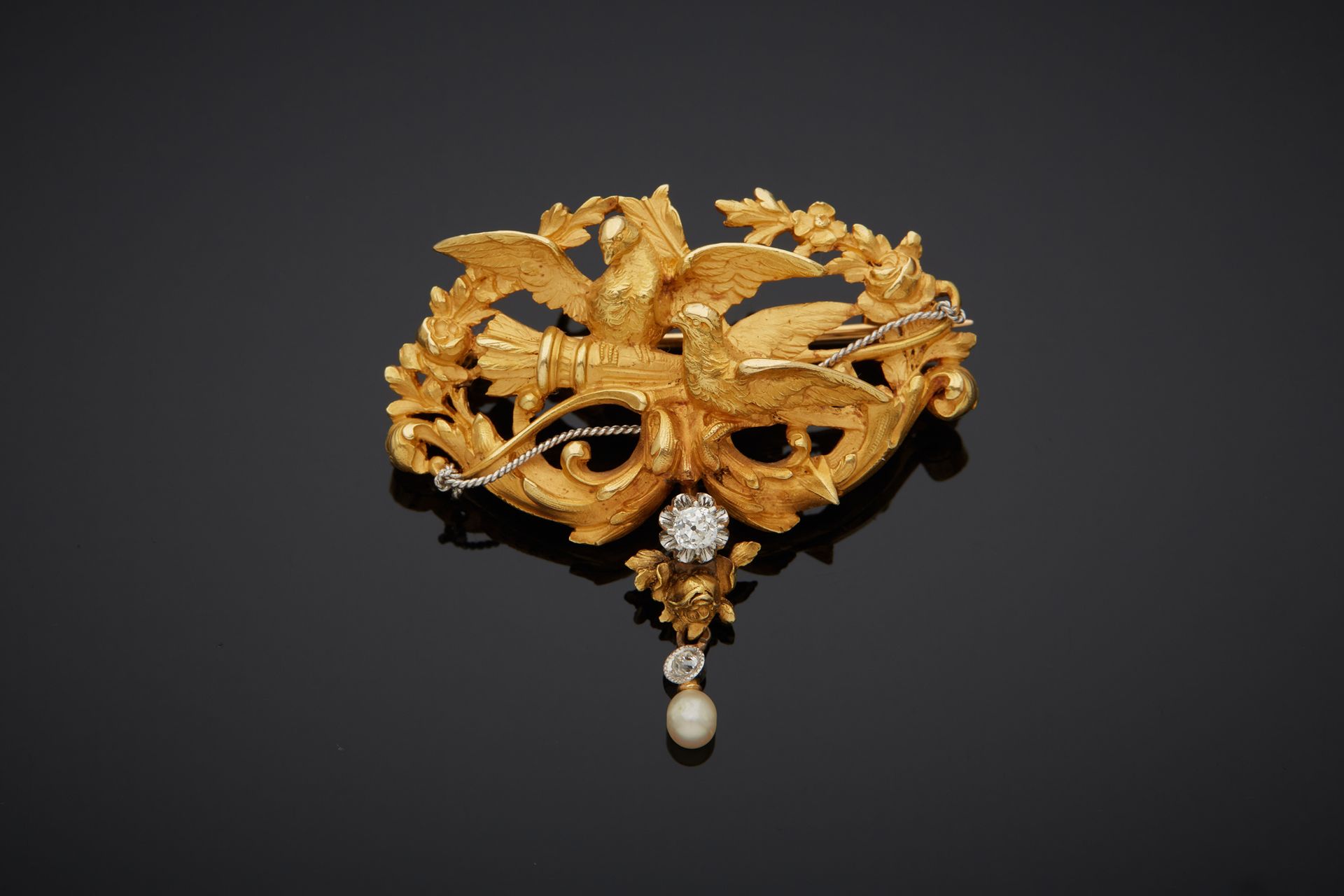 Null Two-tone 18K gold 750‰ brooch, chased with two birds, a quiver and a bow.

&hellip;