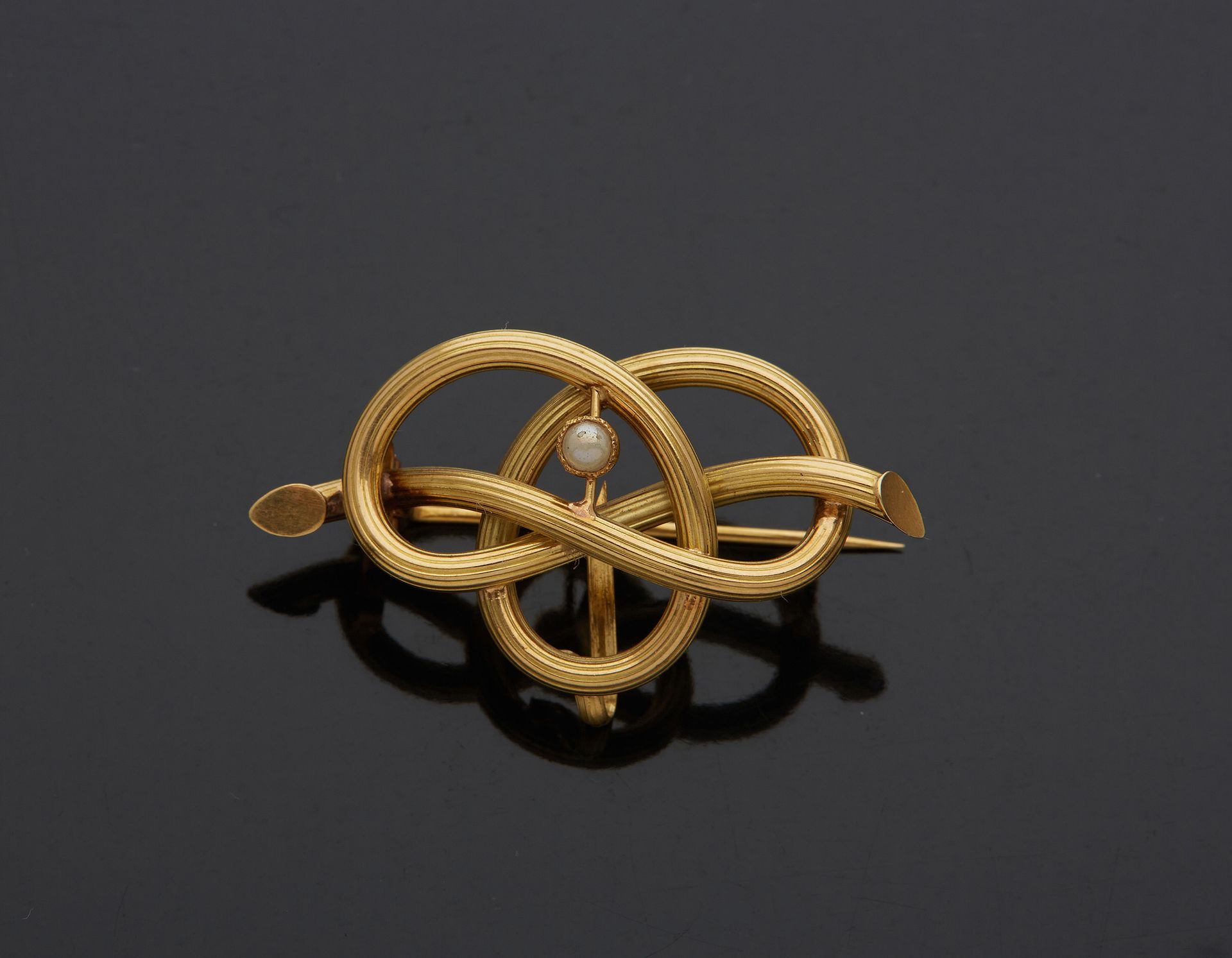 Null 18K黄金750‰胸针，代表一个打结的树枝，镶有半颗珍珠

珍珠。

l.3.20 cm 毛重 1.70 g