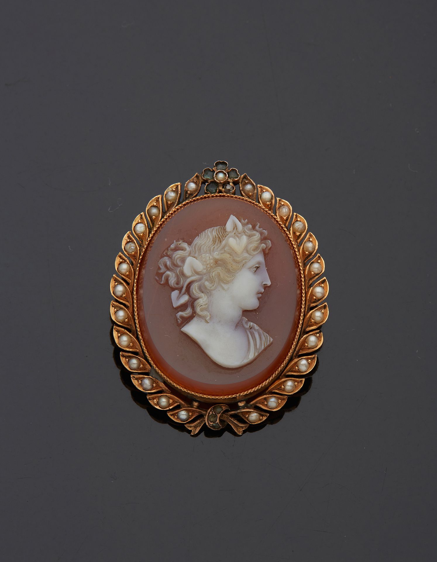 Null 一枚18K黄金750‰的胸针，椭圆形，装饰有玛瑙浮雕，描绘了一个Bacchante的轮廓，周围有半颗珍珠和玫瑰切割钻石。

1818-1919年的省份&hellip;
